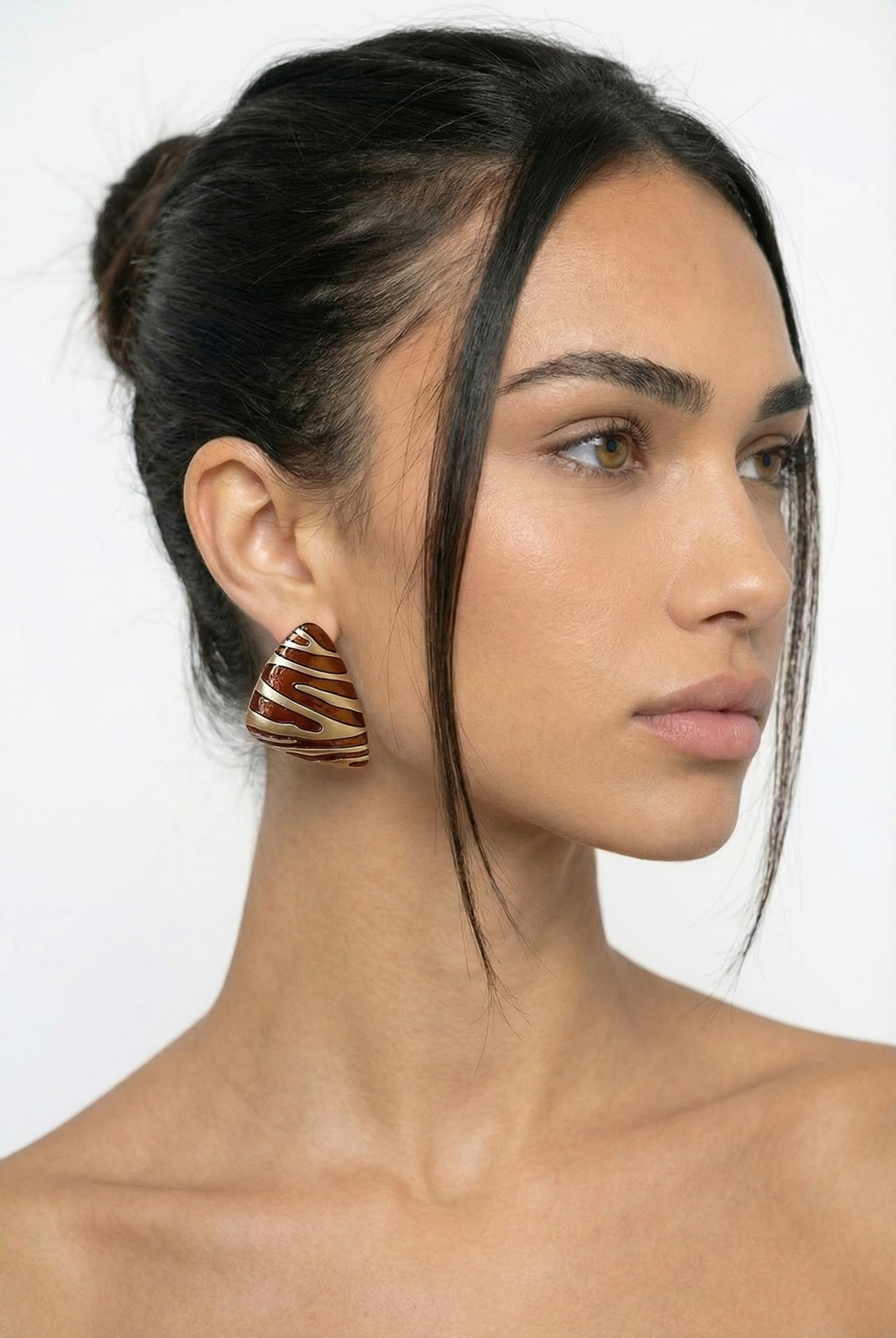Woman wearing a unique earring with a white background