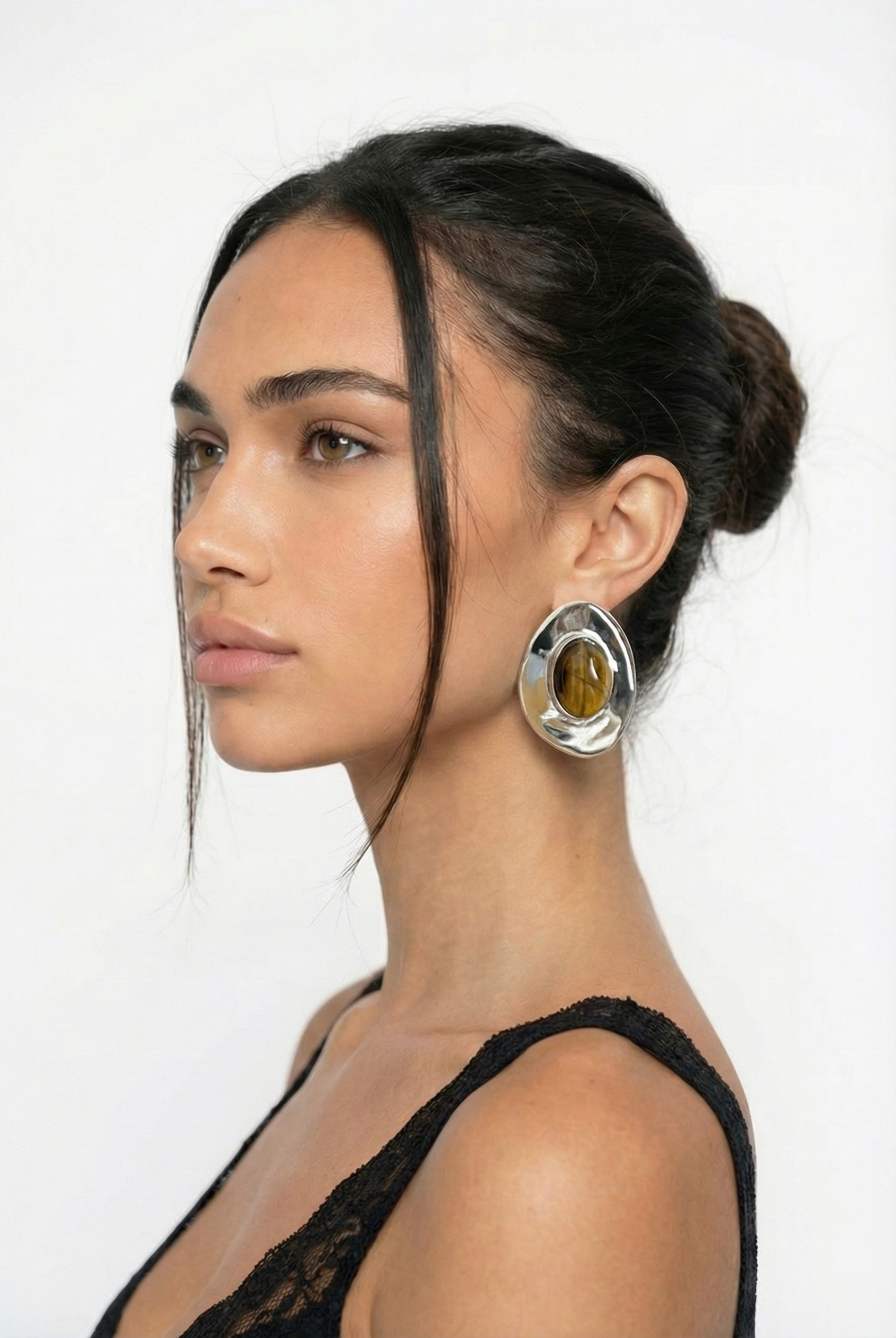 Woman wearing large hoop earrings against a white background