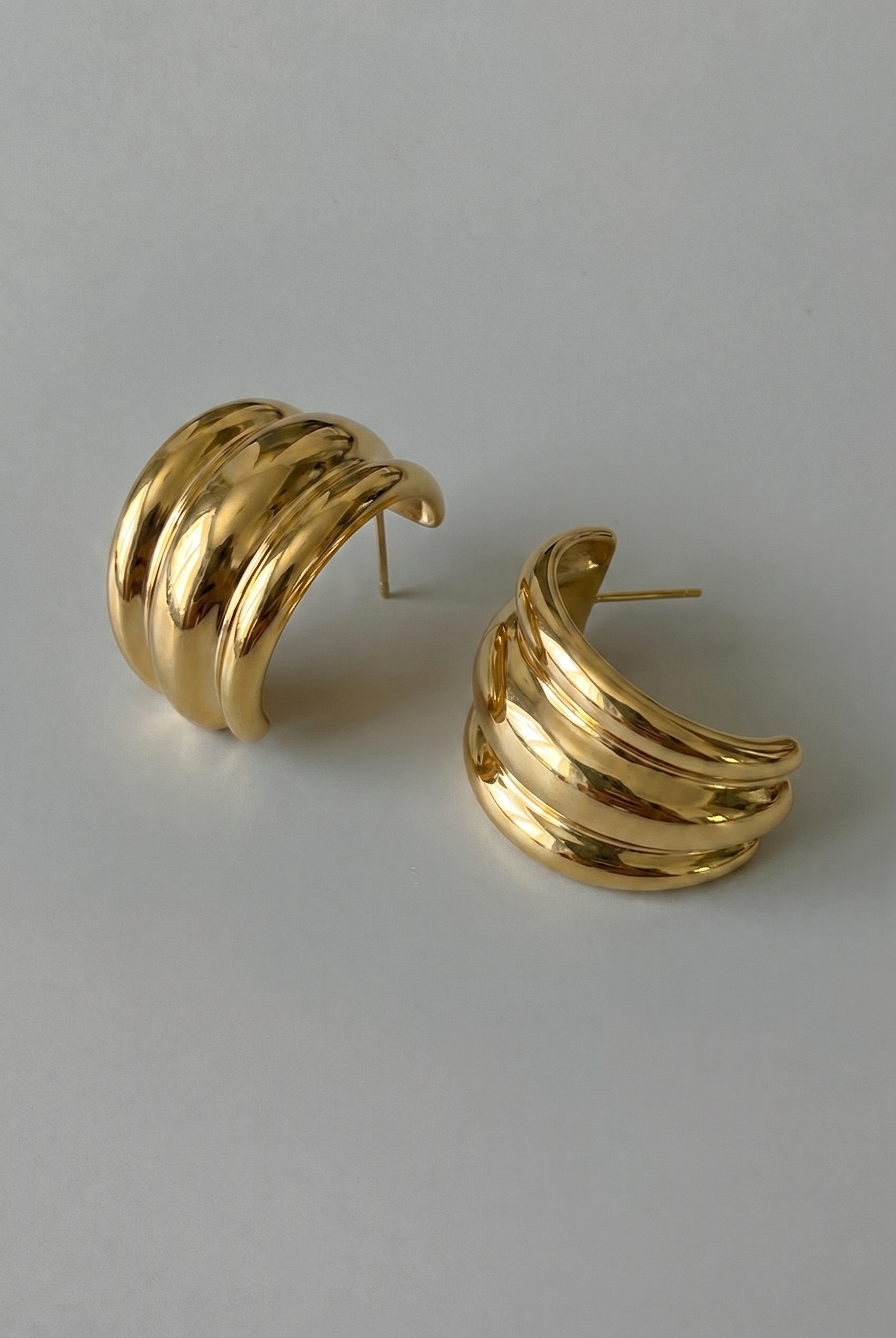 Pair of gold hoop earrings on a light gray background