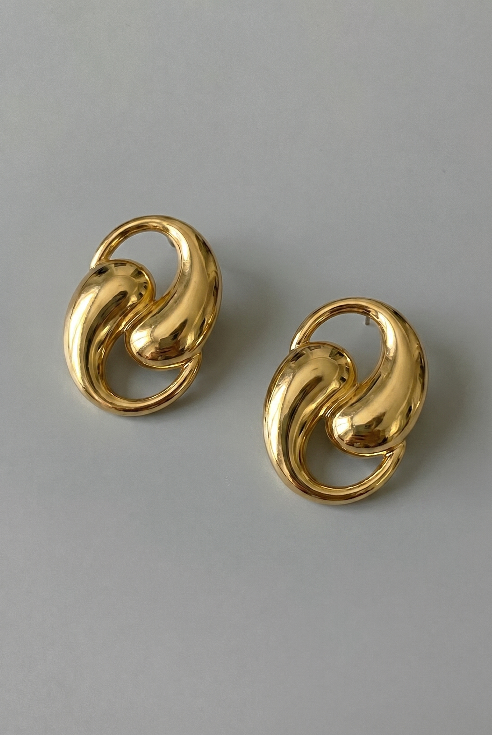 Pair of gold earrings on a gray background