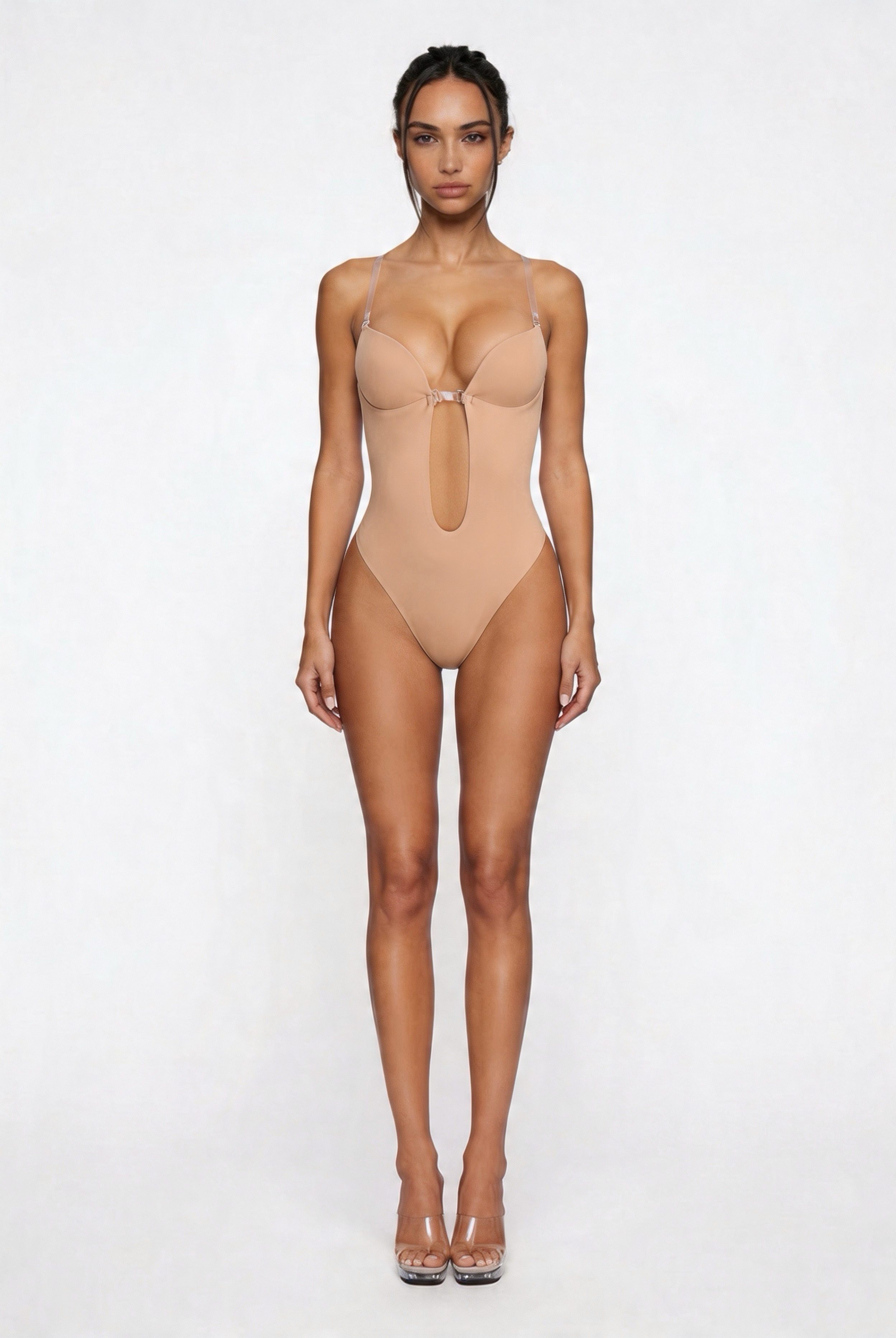 Woman wearing a beige shapewear bodysuit on a white background