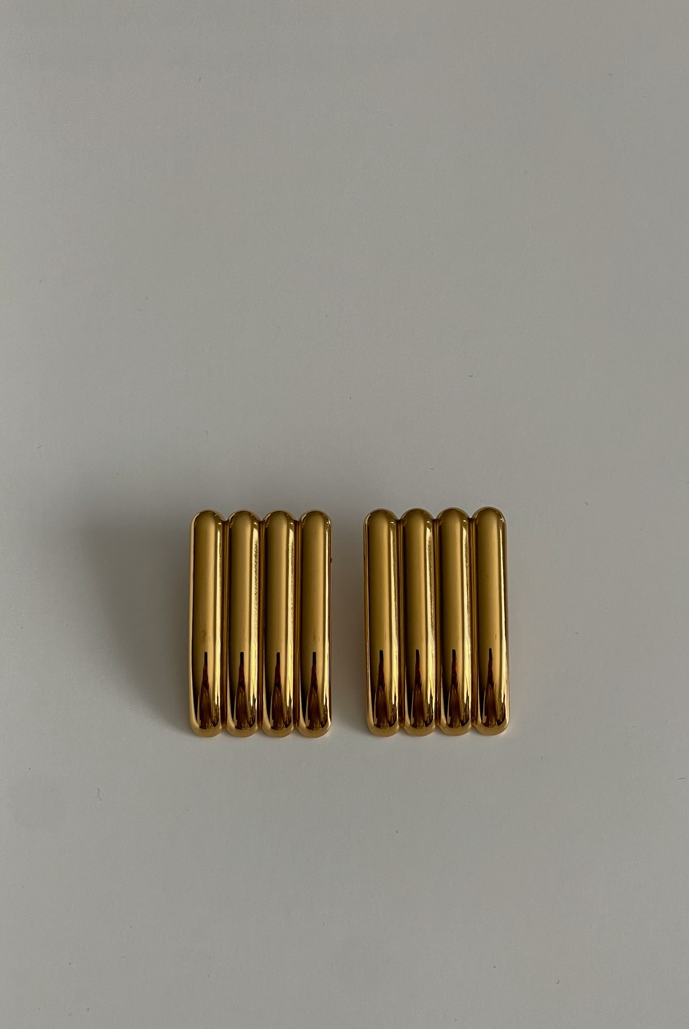 Pair of gold earrings on a light gray background