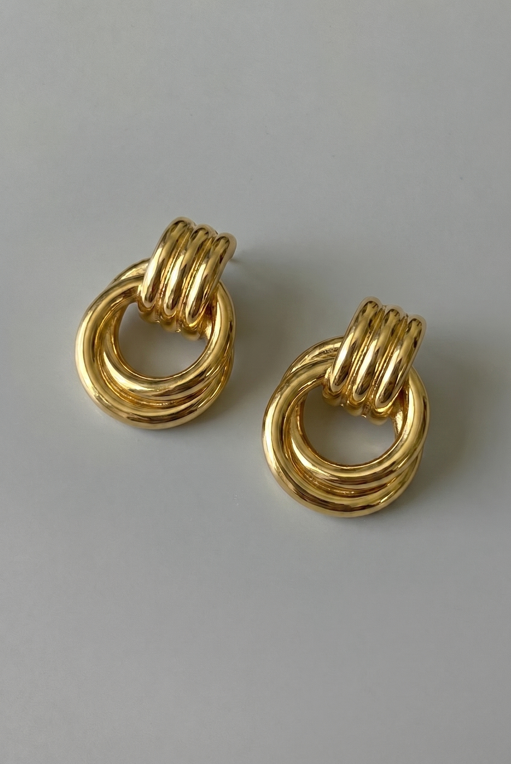Pair of gold hoop earrings on a gray background