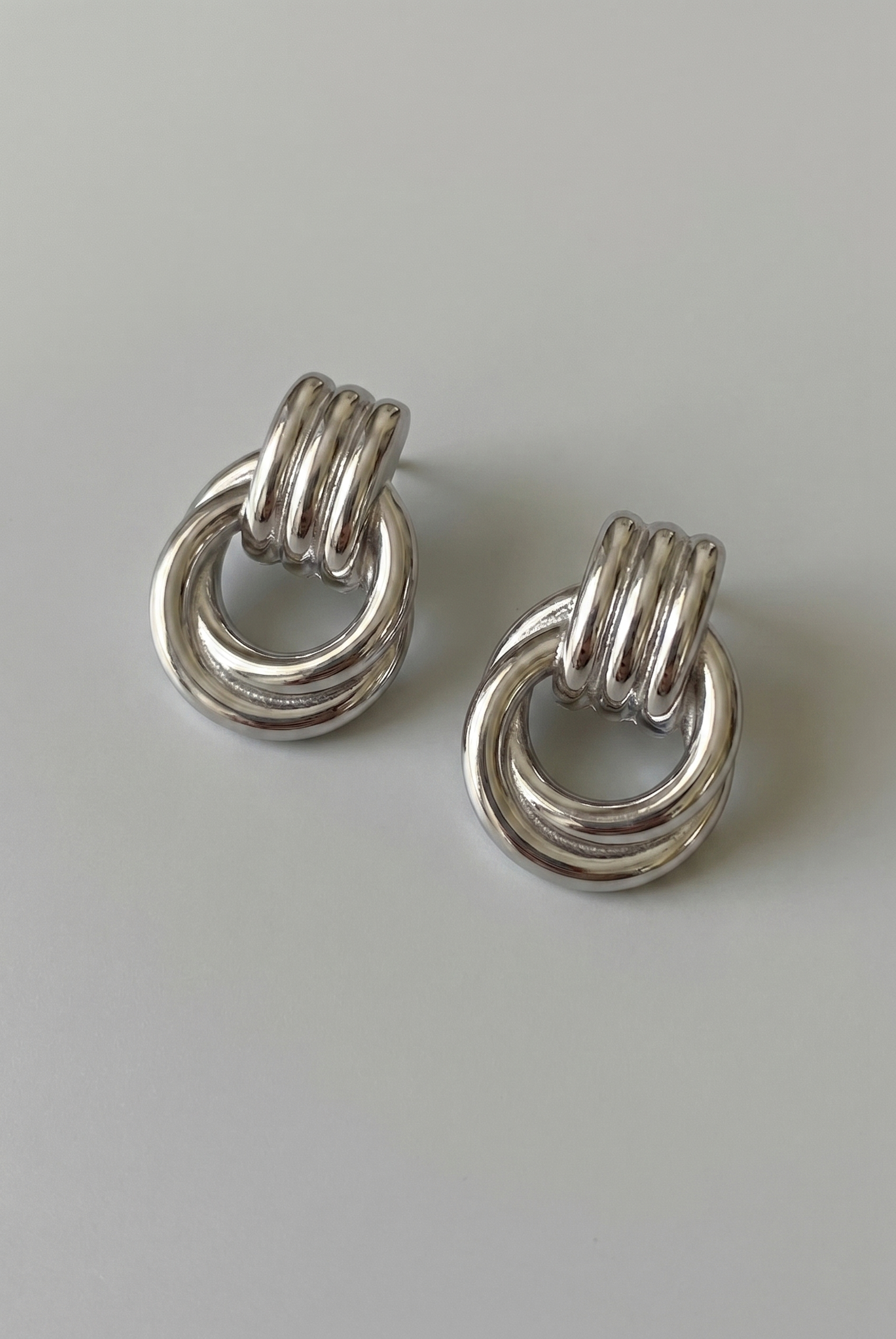 Pair of silver ring earrings on a light gray background