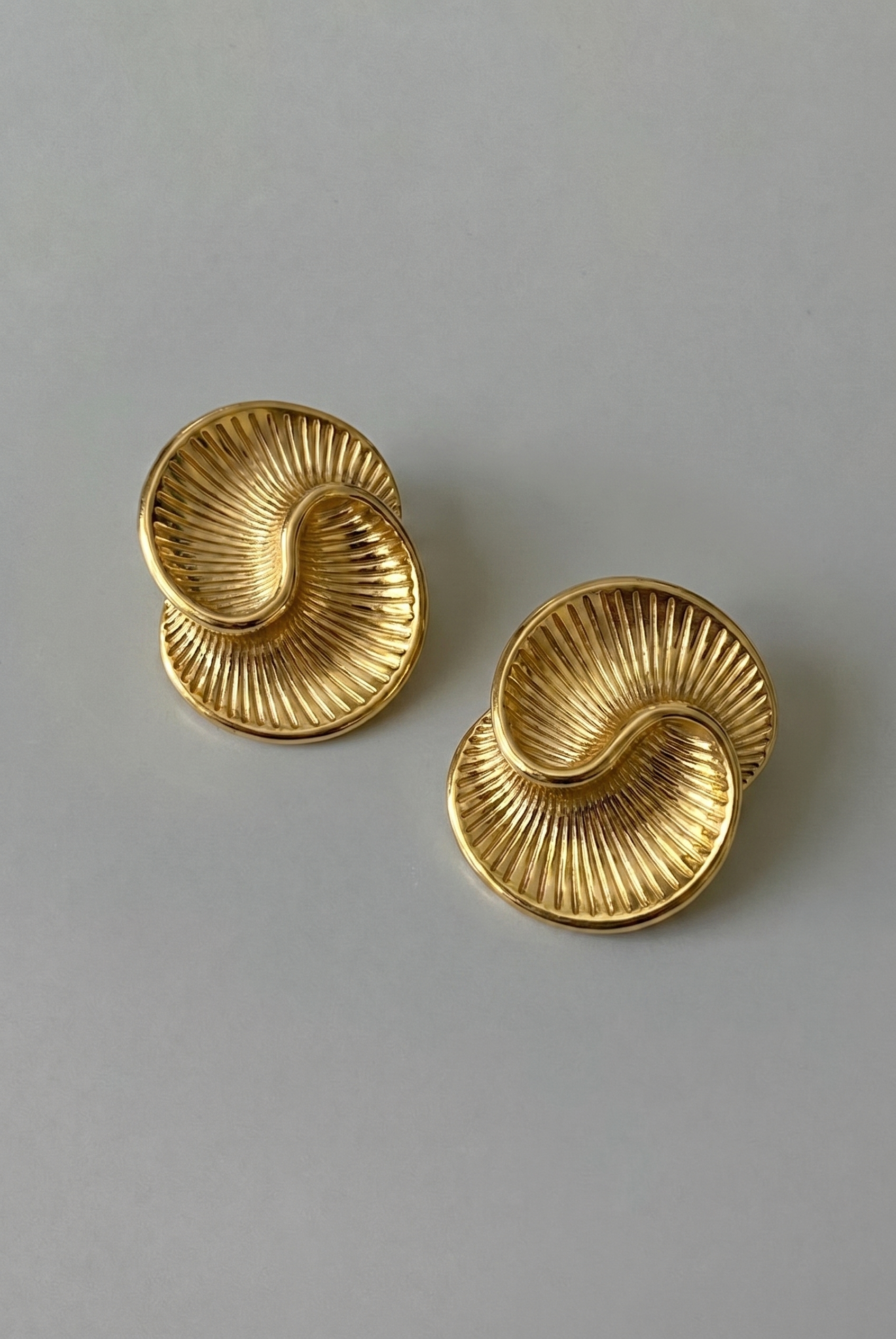 Pair of gold earrings on a gray background