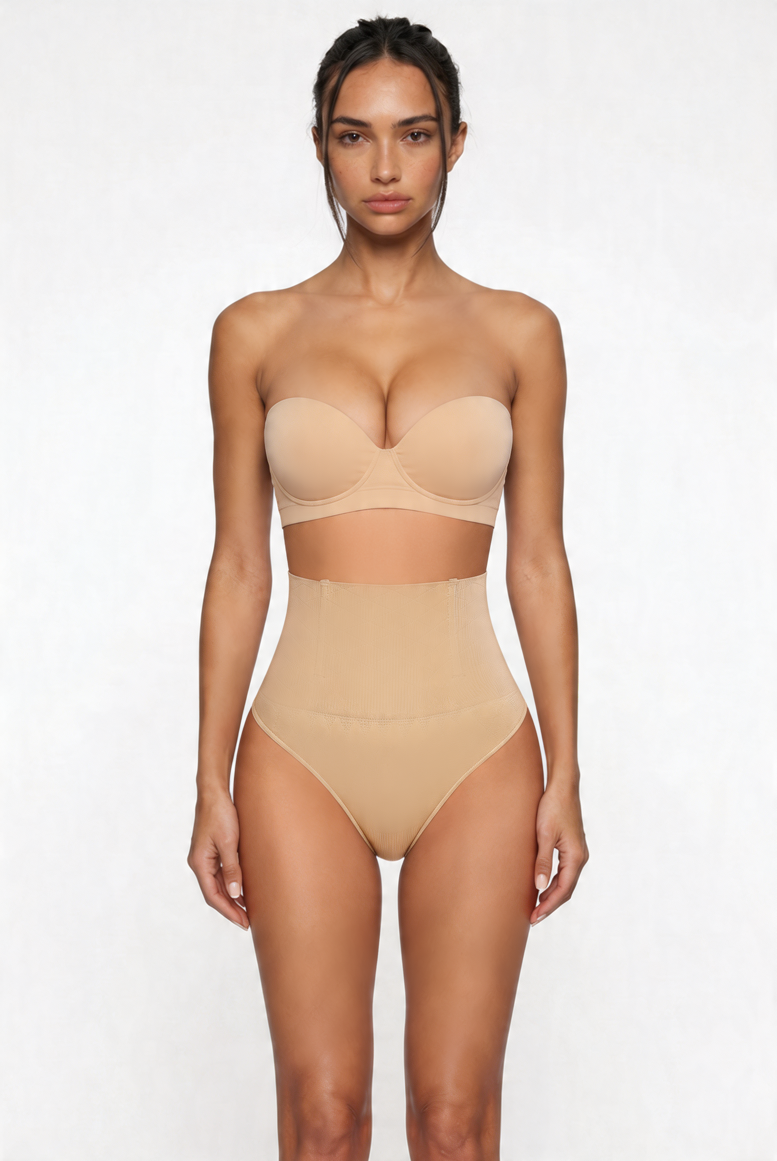 Woman wearing a beige strapless top and high-waisted shapewear bottom on a white background