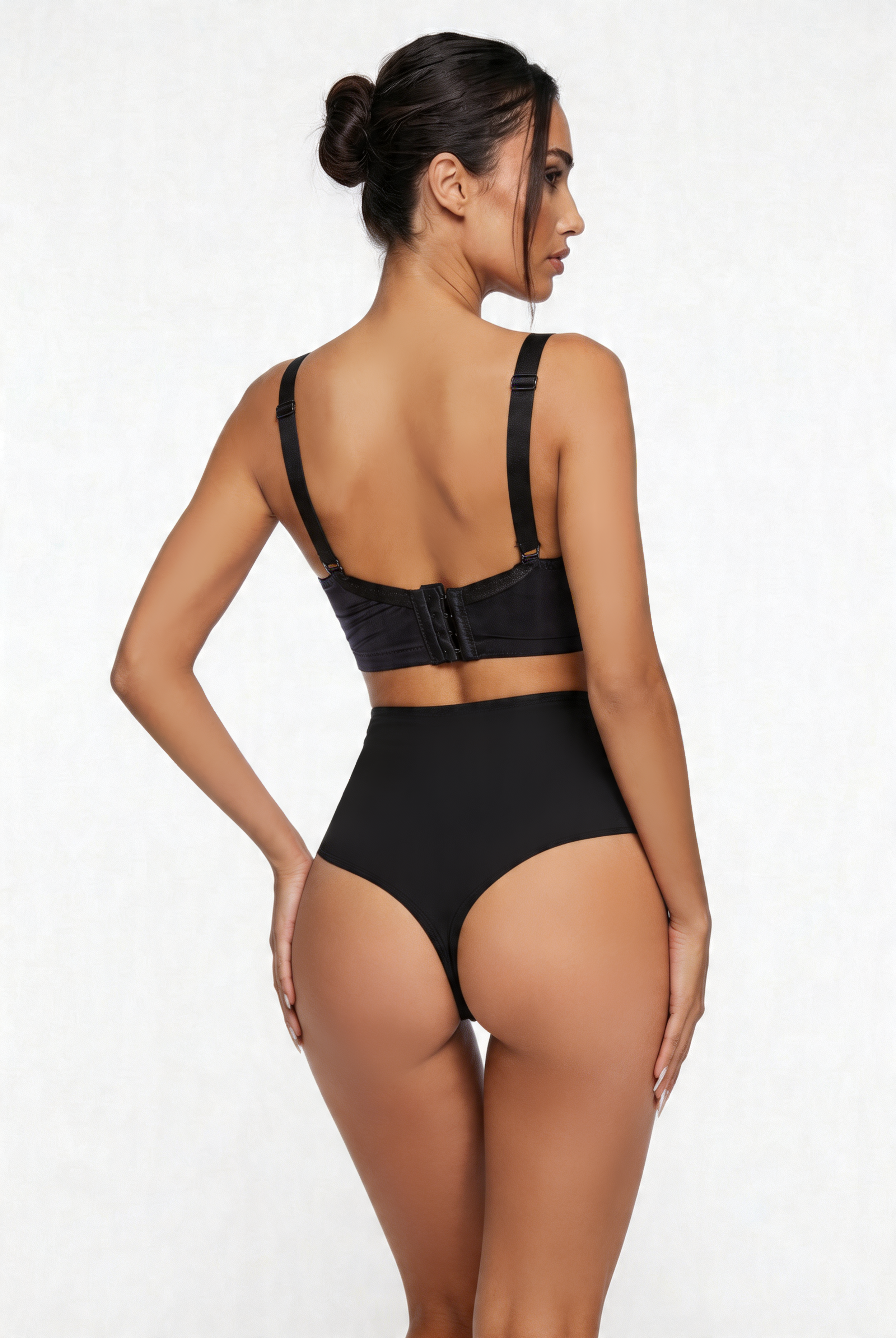 Woman wearing a black shapewear set on a white background