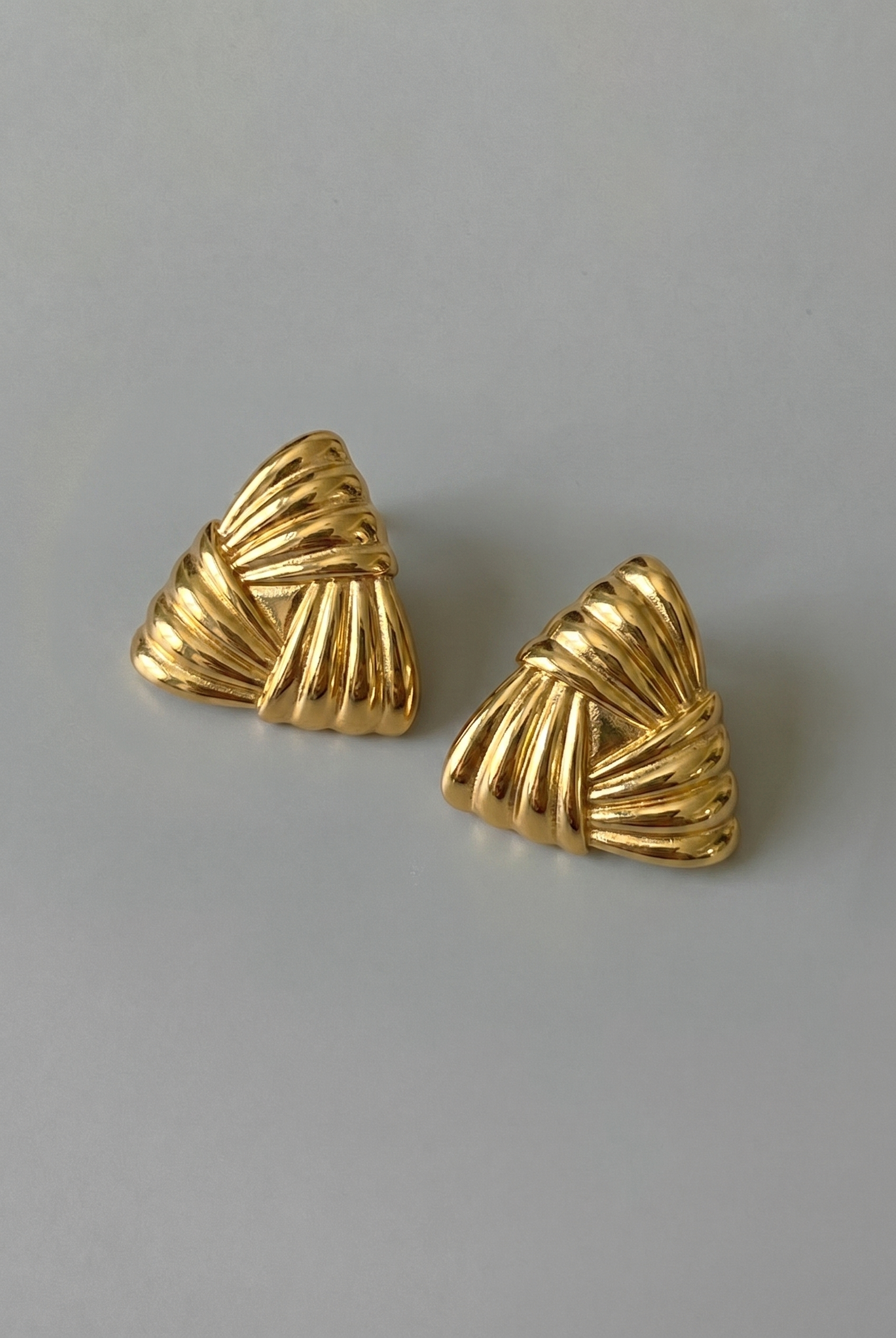 Pair of gold earrings on a gray background