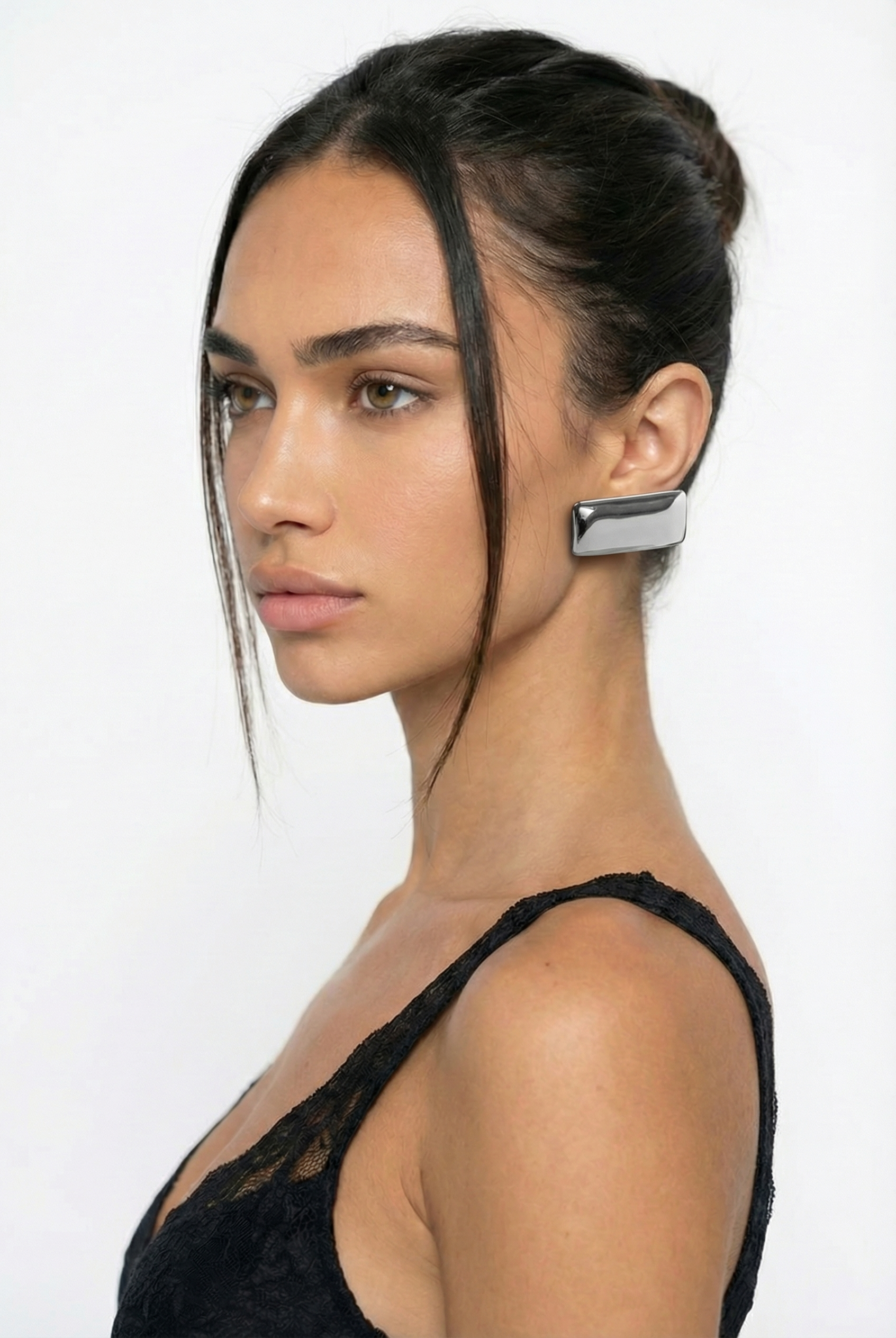 Woman wearing a unique earring on a white background