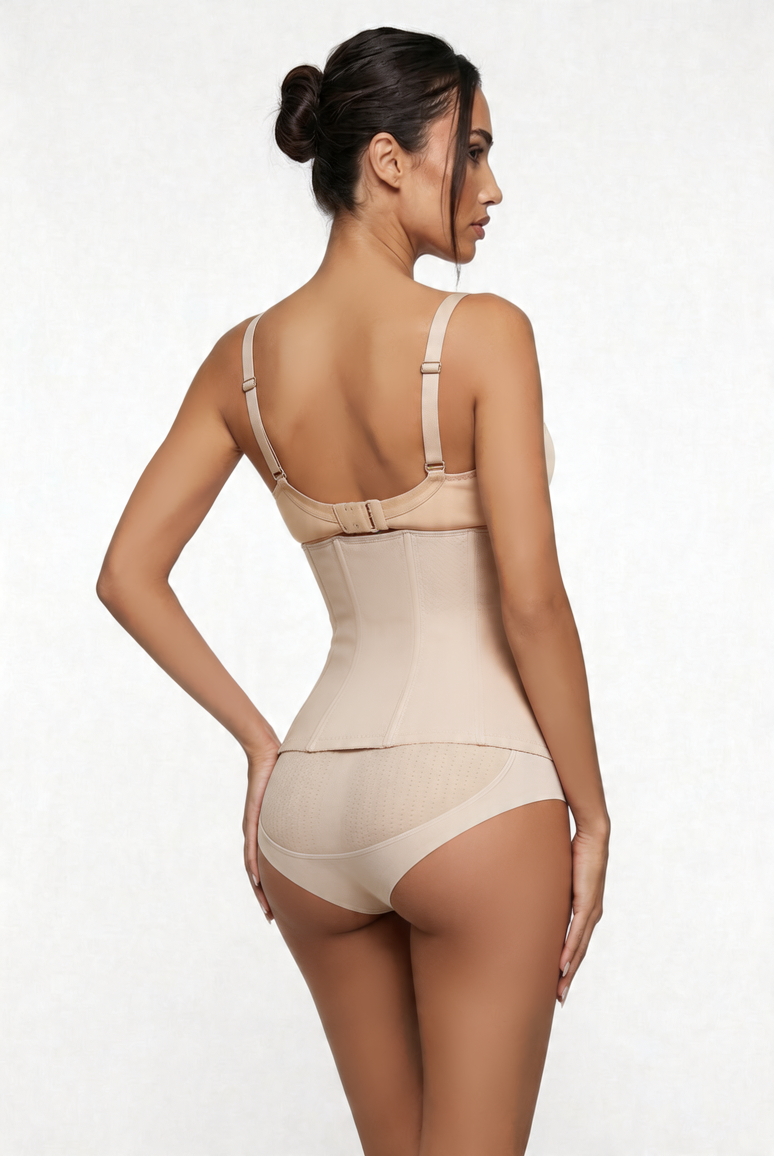 Woman wearing a beige shapewear bodysuit on a white background