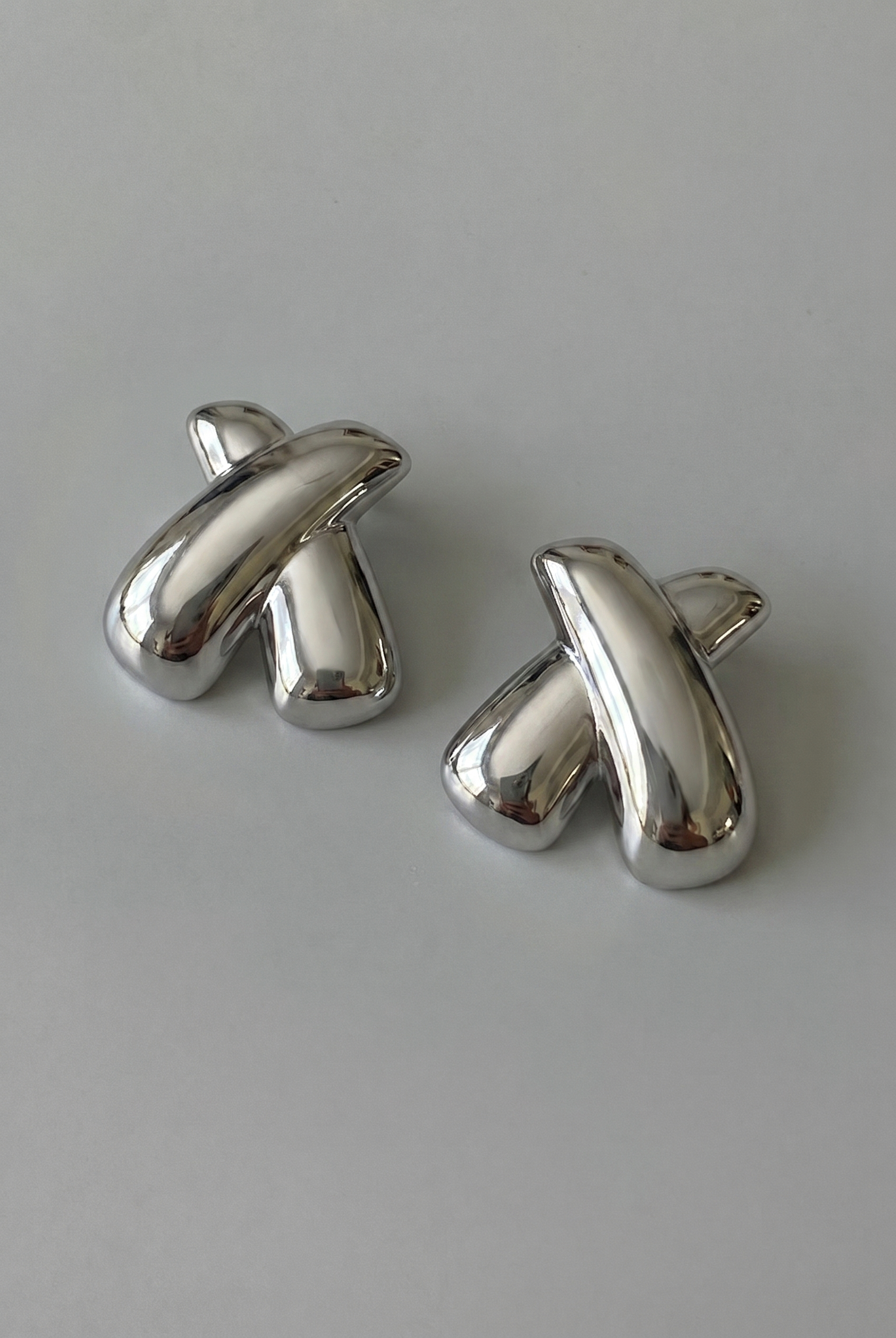 Pair of silver cufflinks on a light gray background