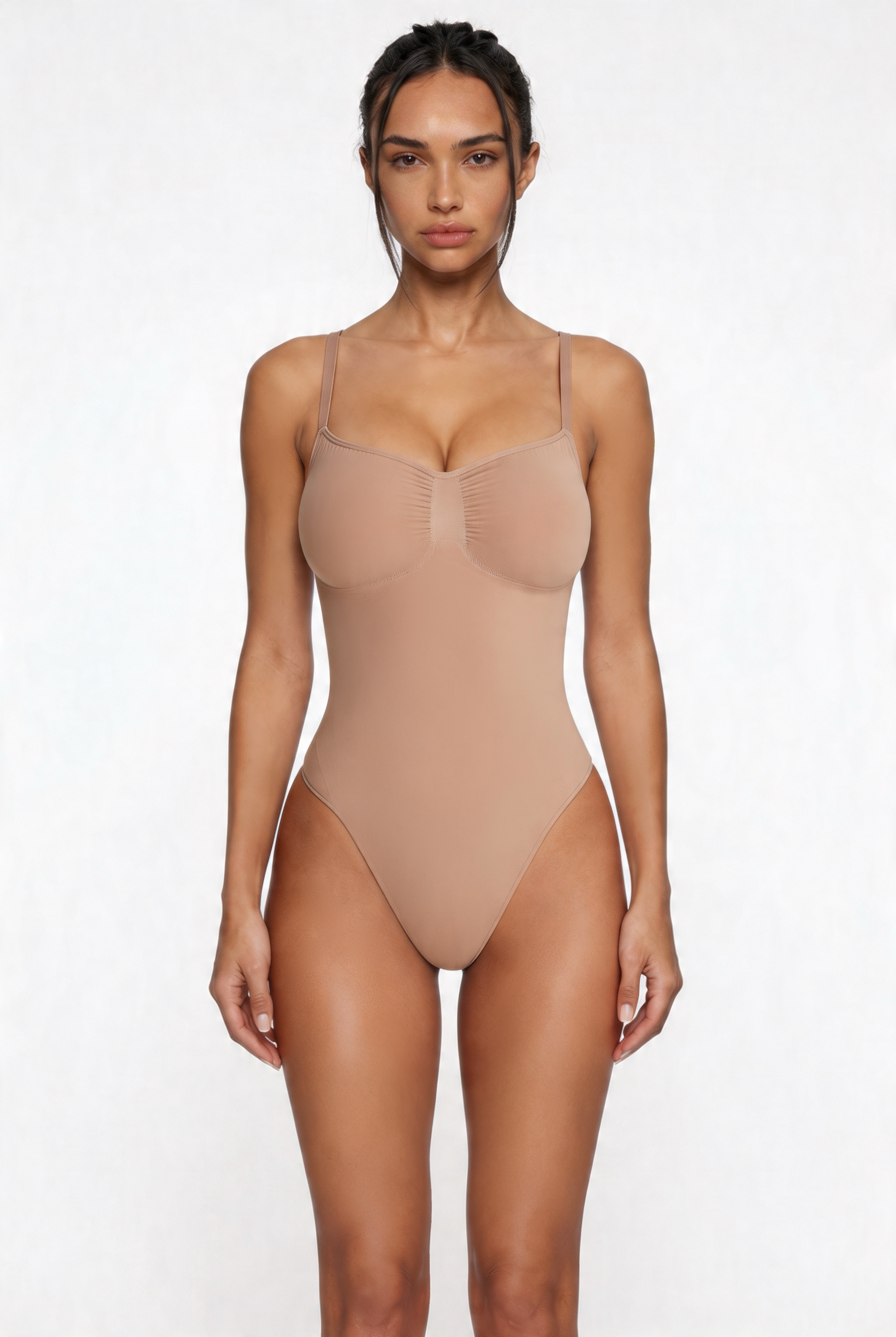 Woman wearing a beige shapewear bodysuit against a white background