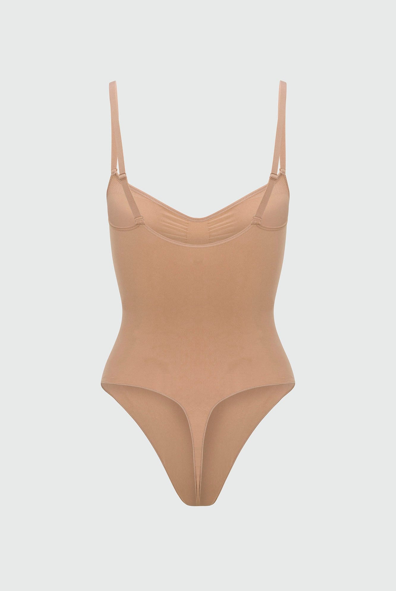 Beige shapewear bodysuit with thin straps on a light gray background