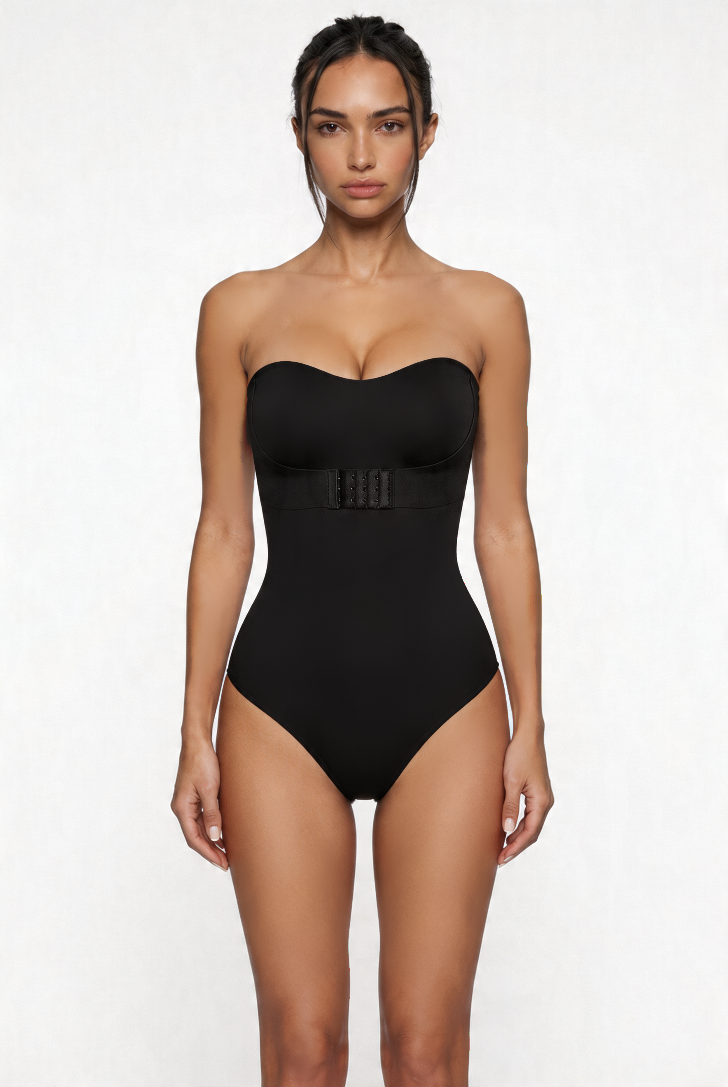 Woman wearing a black strapless shapewear bodysuit on a white background