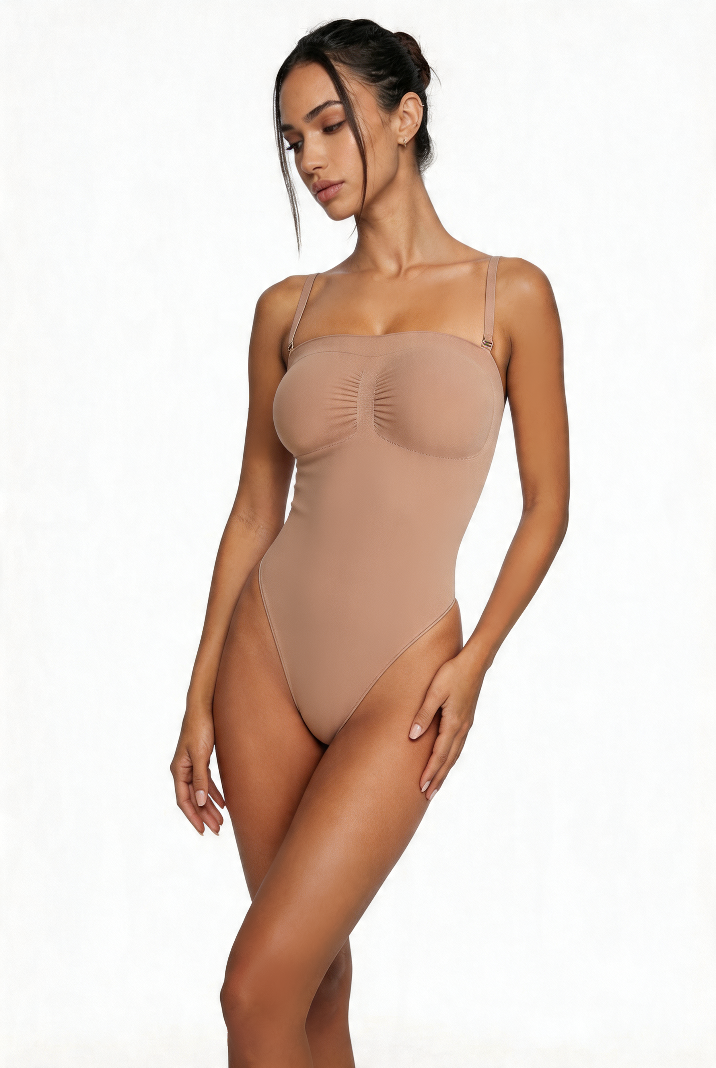 Woman wearing a beige shapewear bodysuit on a white background