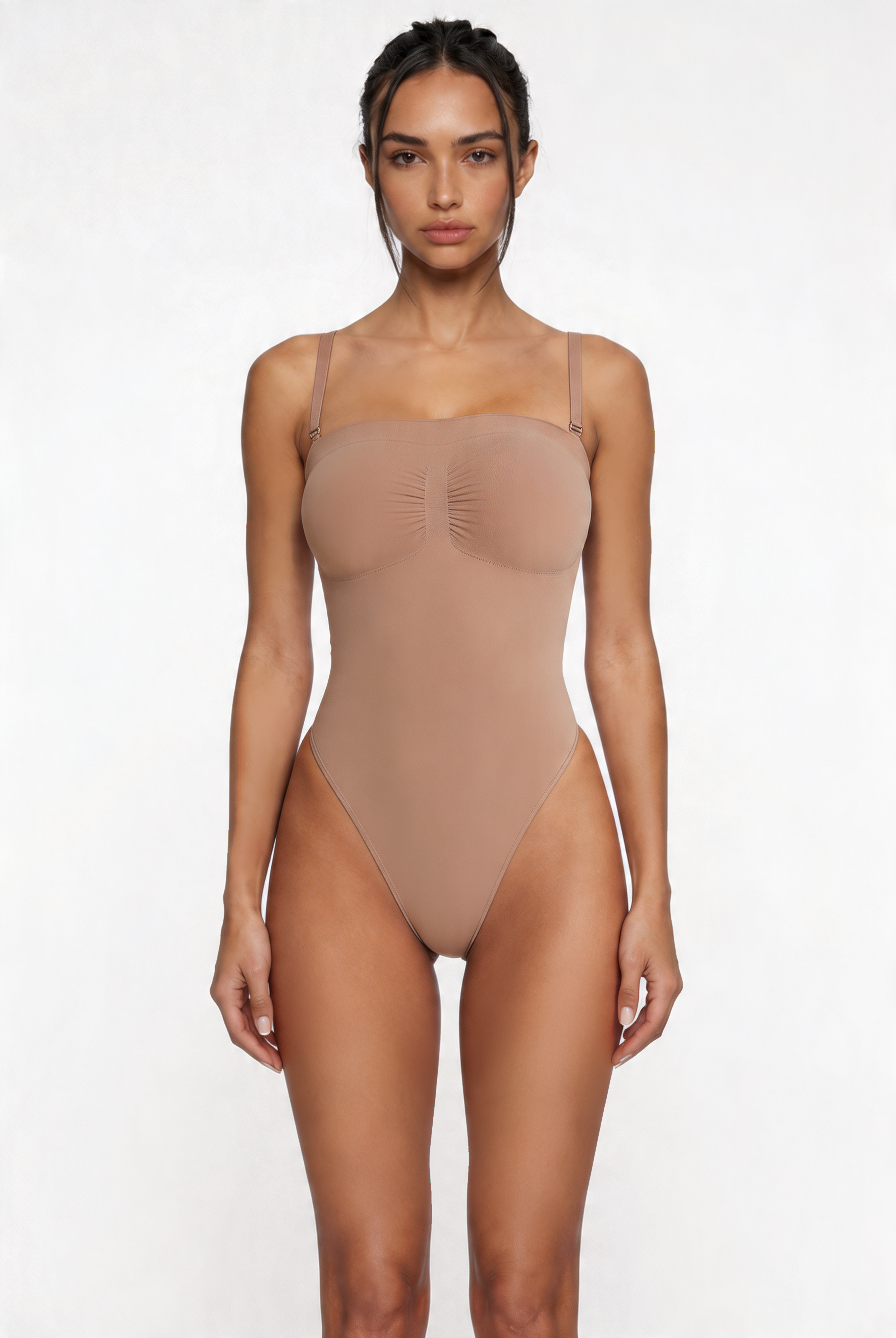 Woman wearing a beige shapewear bodysuit on a white background