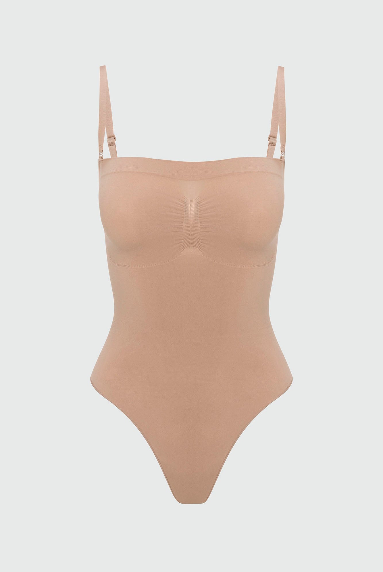 Beige shapewear bodysuit with thin straps on a light gray background