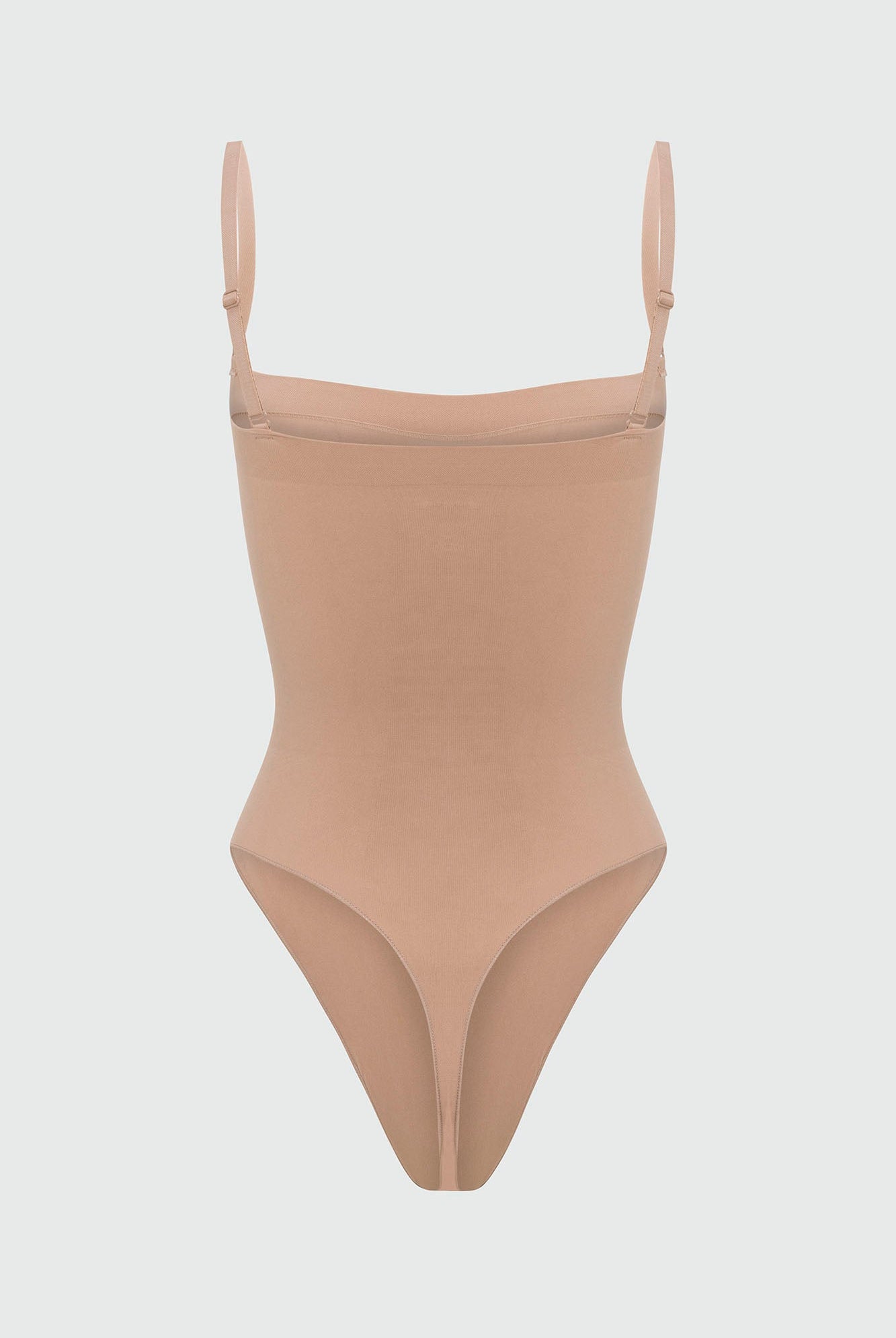 Beige shapewear bodysuit with thin straps on a light gray background