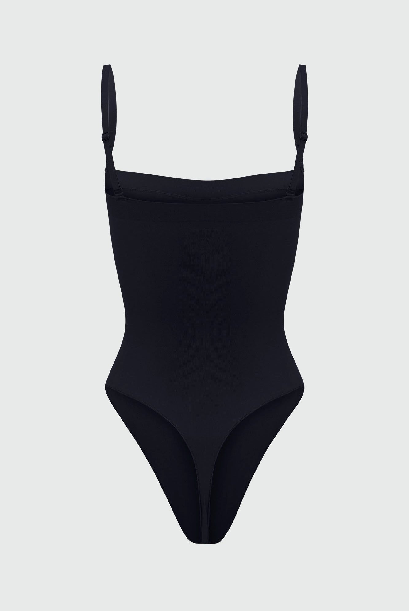Black shapewear bodysuit with thin removable straps on a light gray background