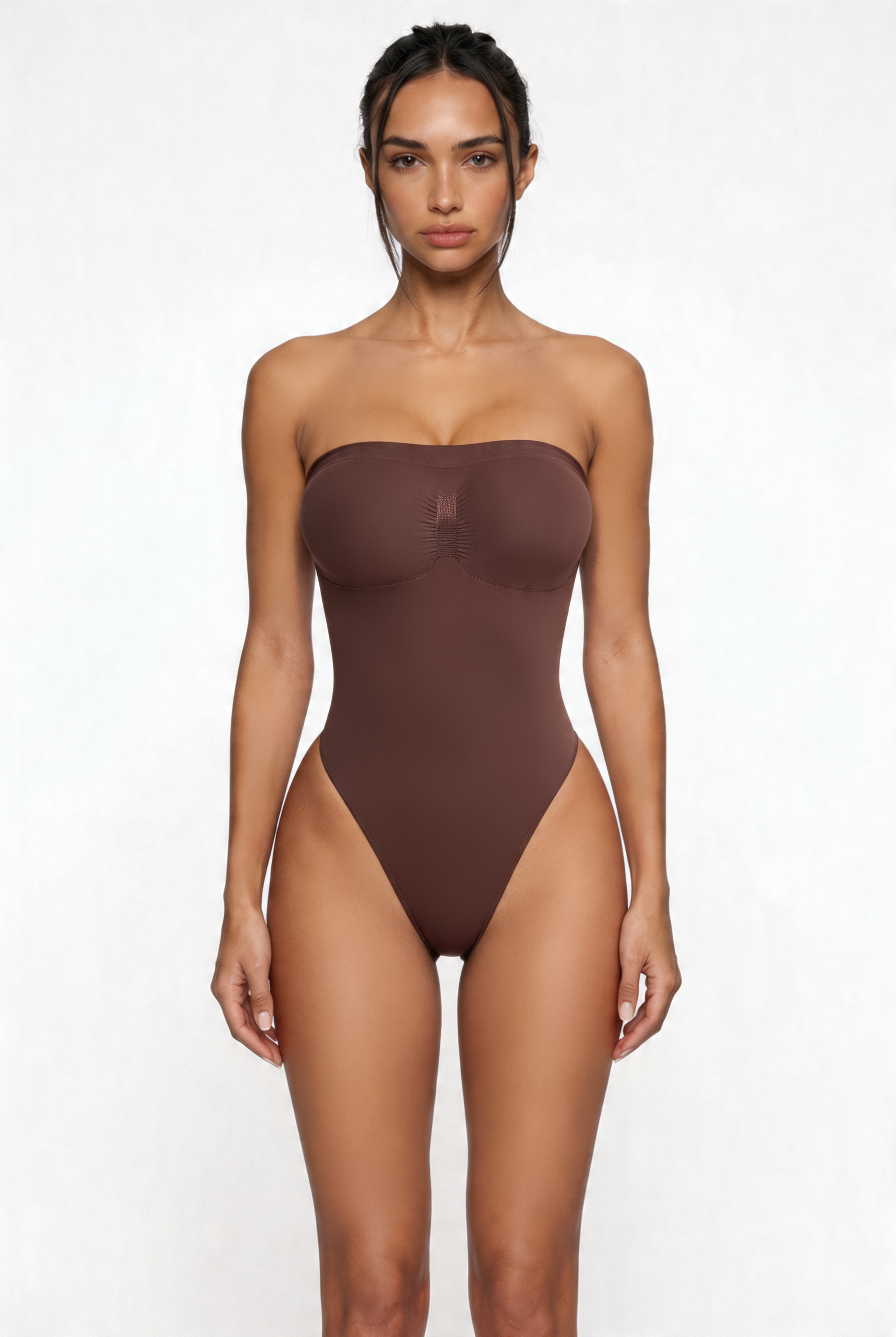 Woman wearing a brown strapless shapewear bodysuit on a white background