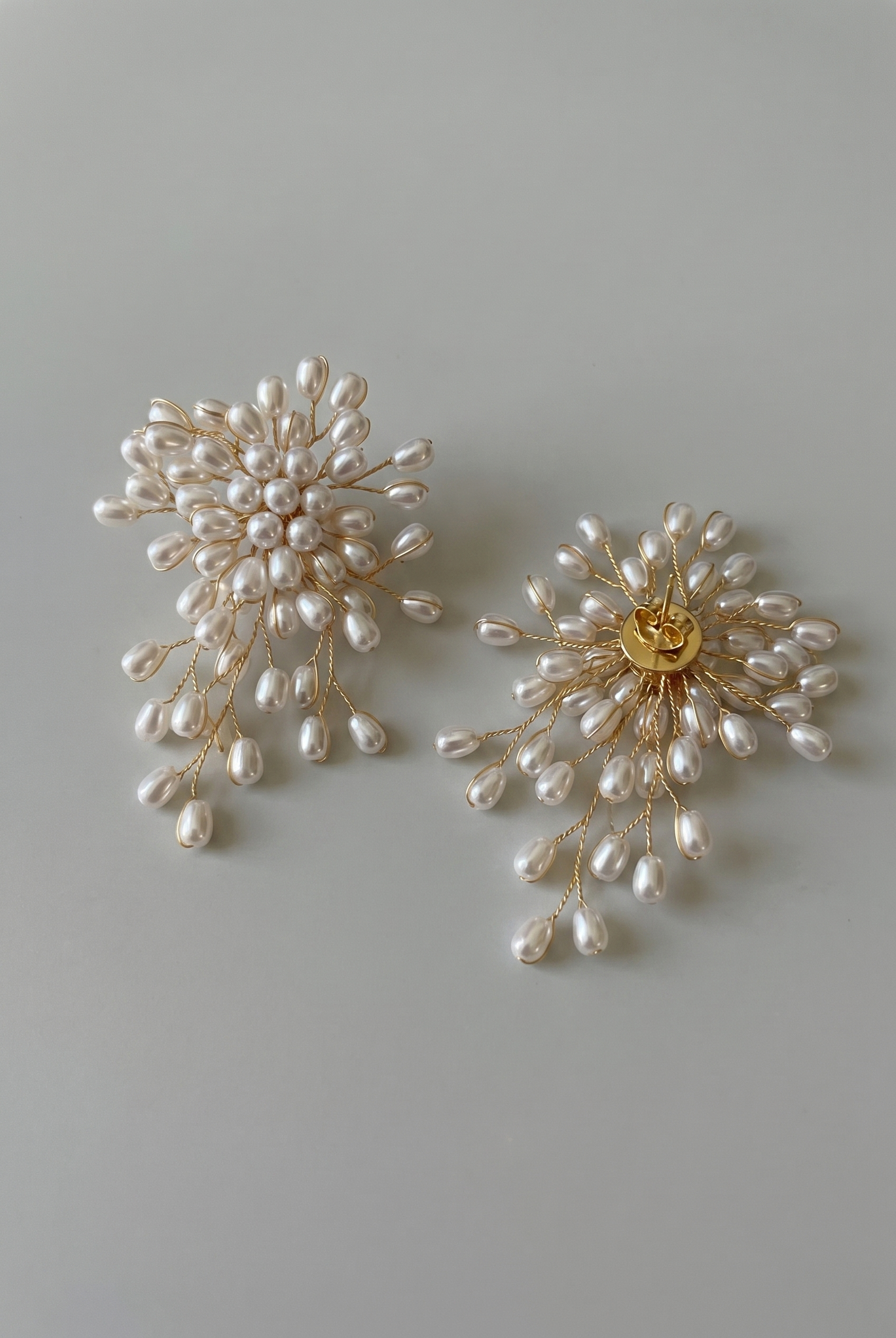 Pair of pearl earrings on a light gray background