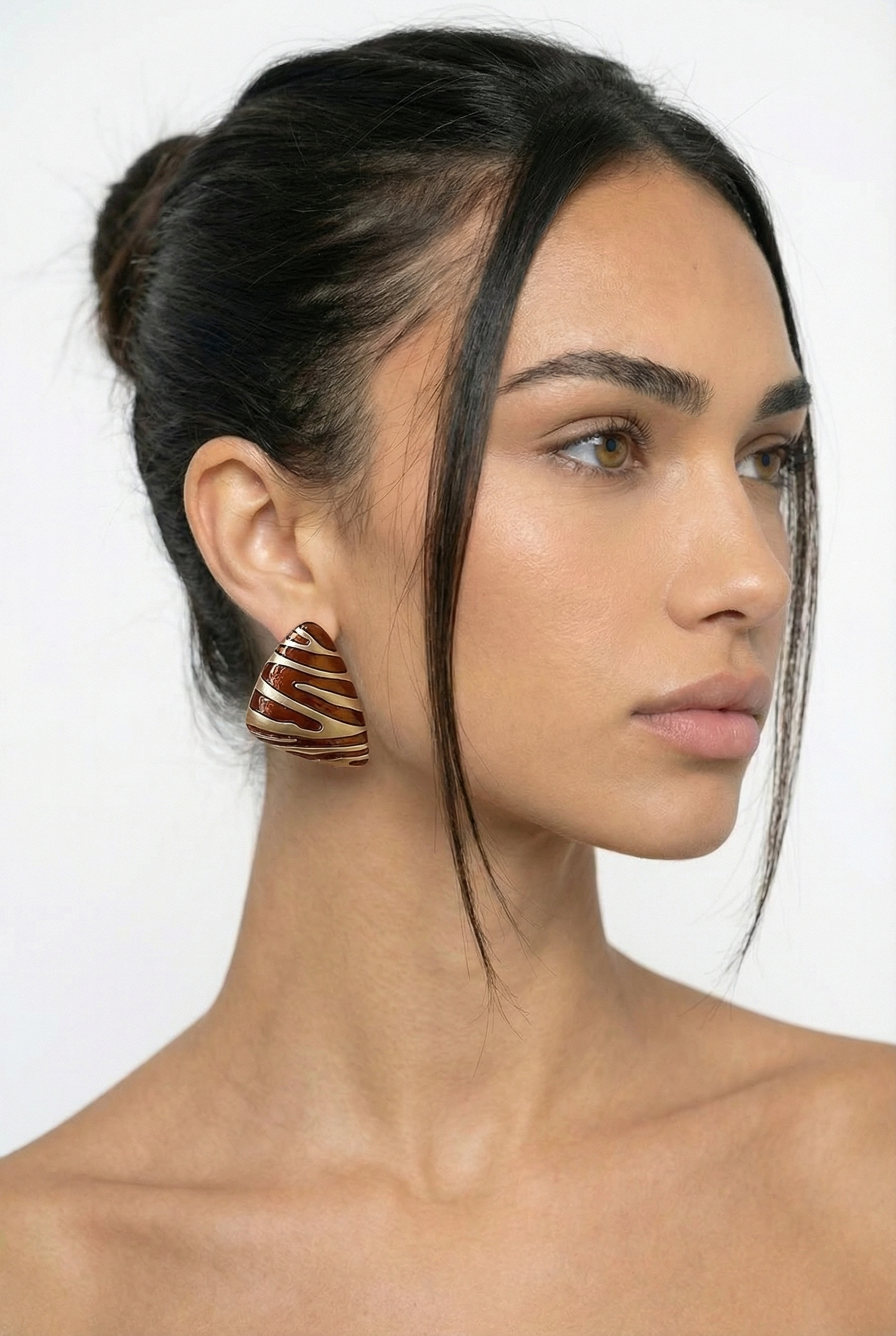 Woman wearing a unique earring with a white background