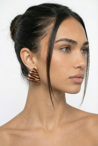 Woman wearing a unique earring with a white background