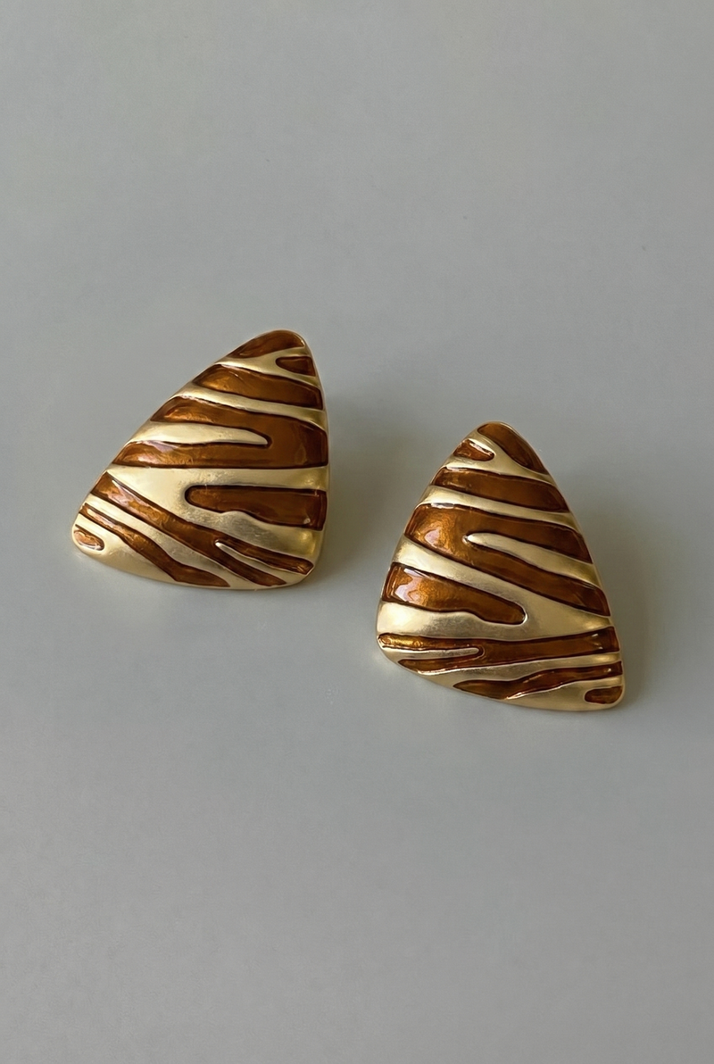 Pair of triangular earrings with striped pattern on a gray background