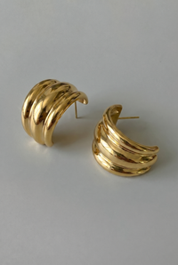 Pair of gold hoop earrings on a light gray background