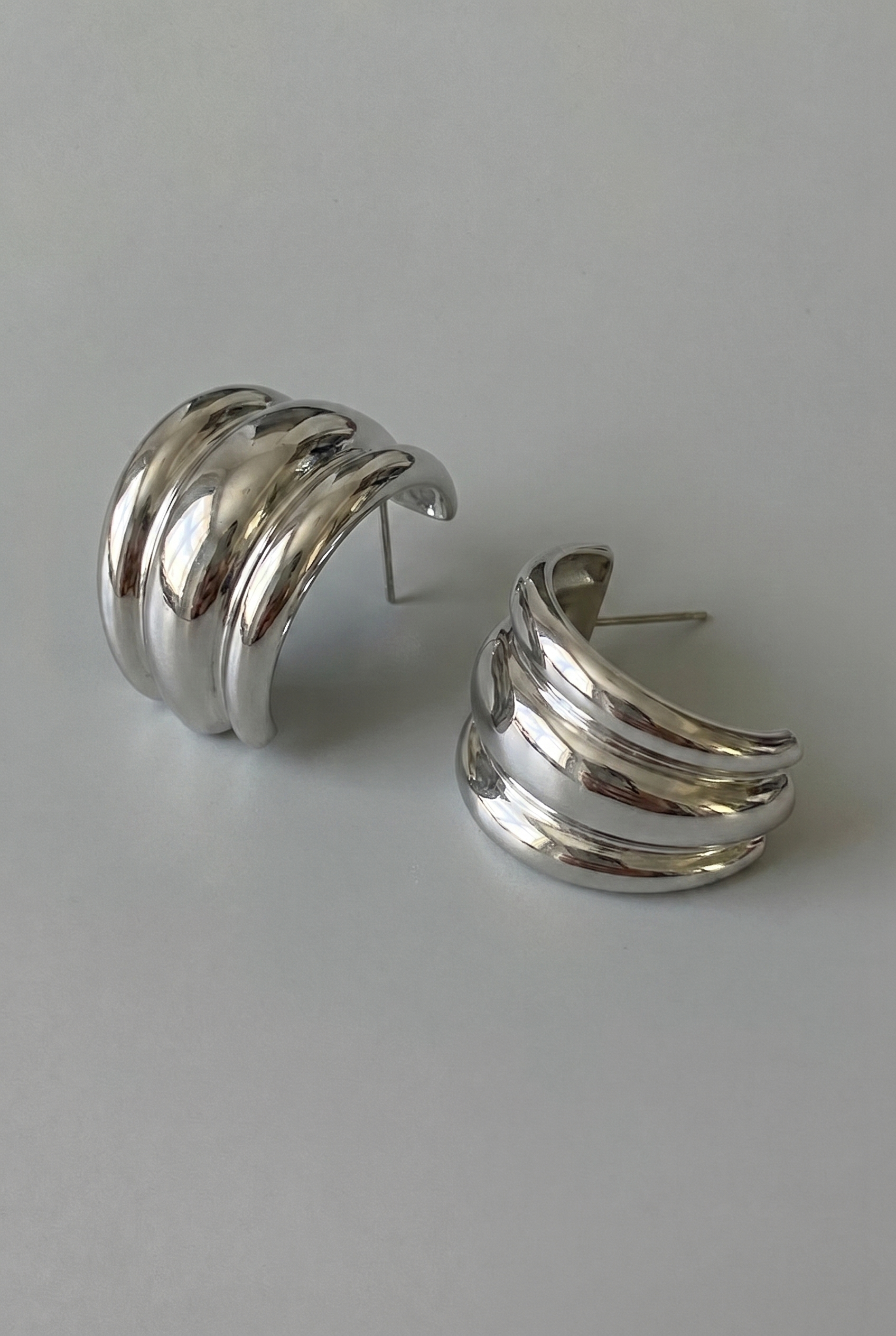 Pair of silver hoop earrings on a light gray background