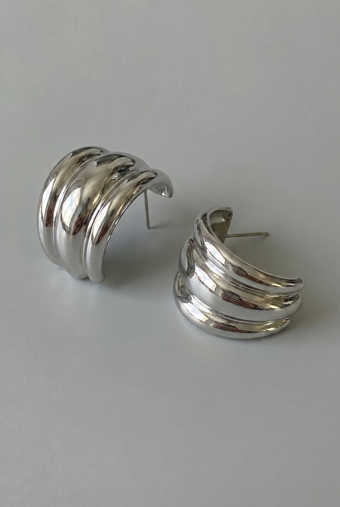 Pair of silver hoop earrings on a light gray background