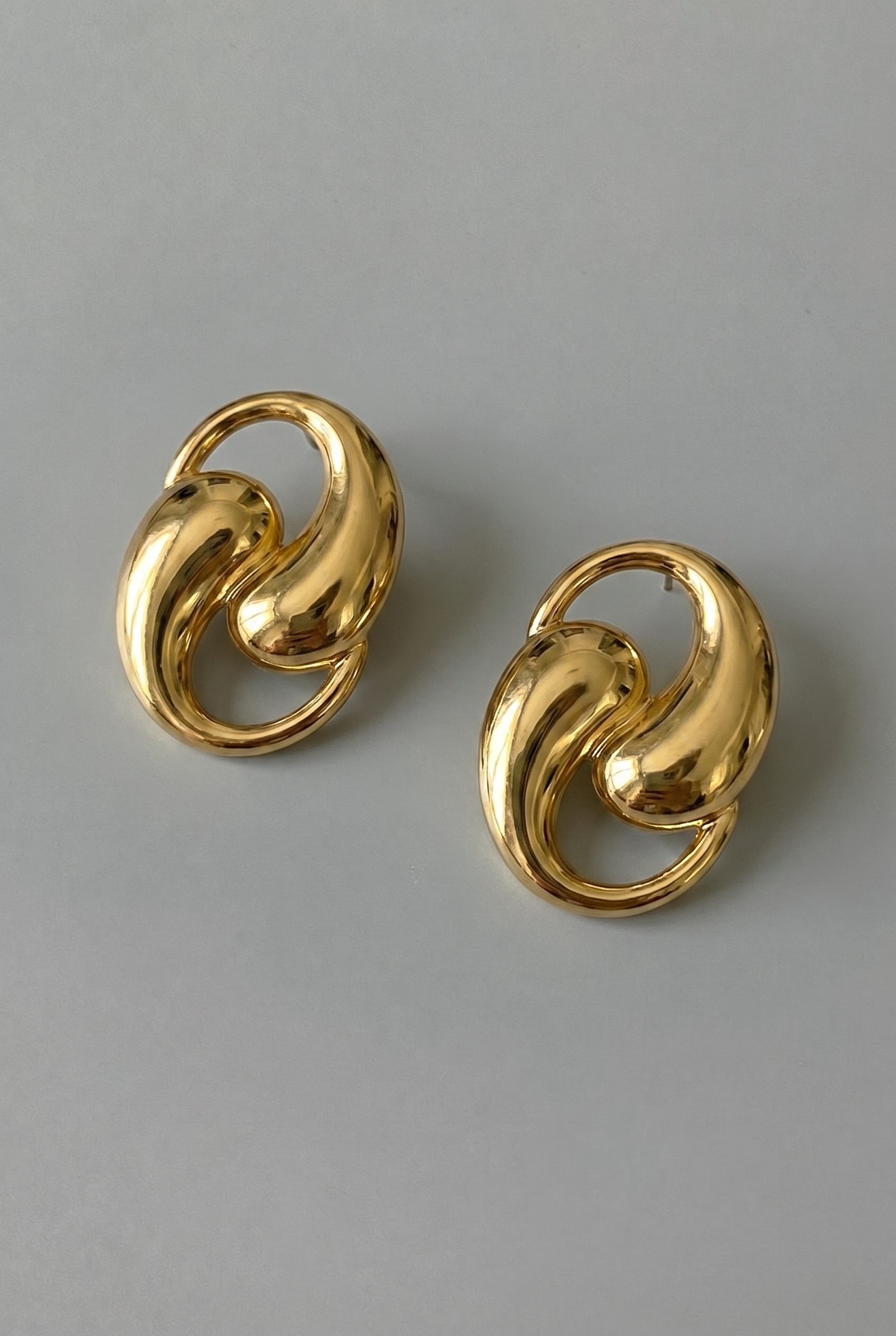 Pair of gold earrings on a gray background