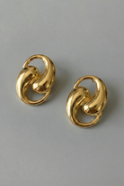 Pair of gold earrings on a gray background