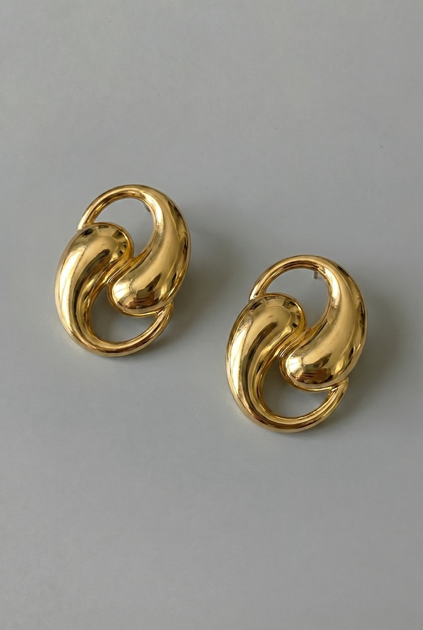 Pair of gold earrings on a gray background