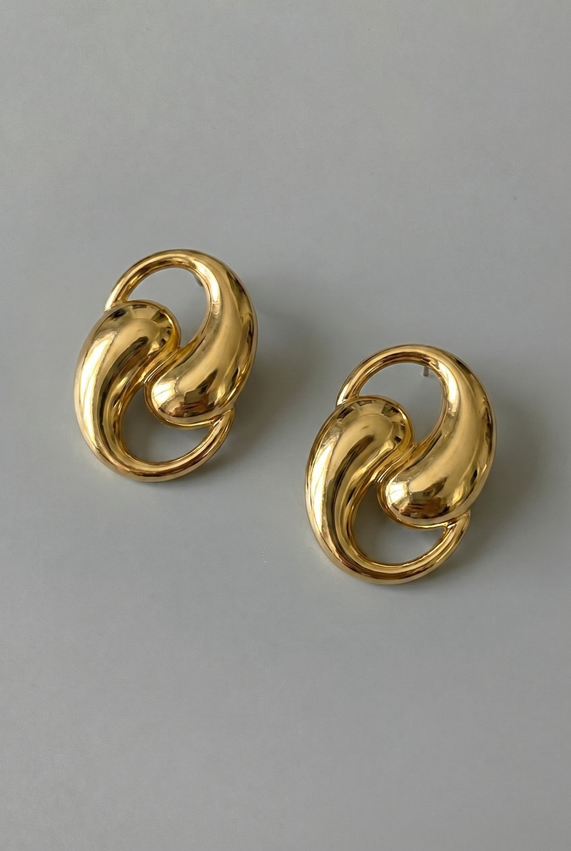 Pair of gold earrings on a gray background
