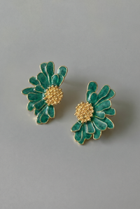 Pair of green floral earrings with gold centers on a gray background
