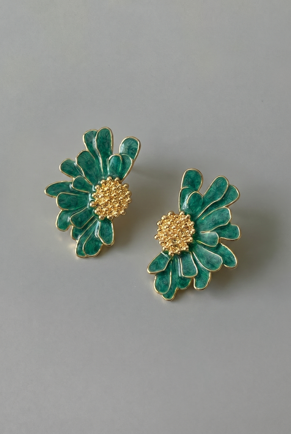 Pair of green floral earrings with gold centers on a gray background