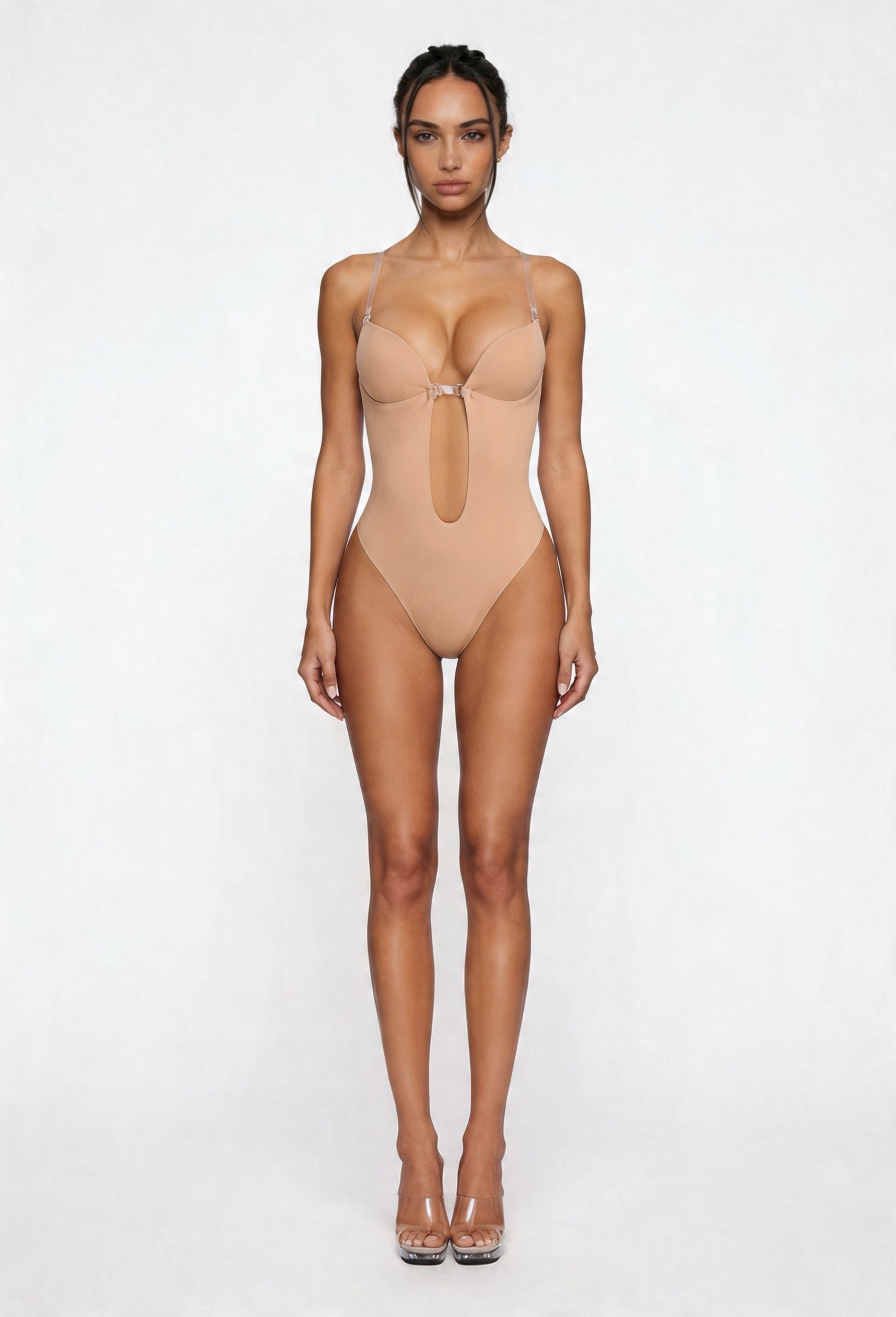 Woman wearing a beige shapewear bodysuit on a white background