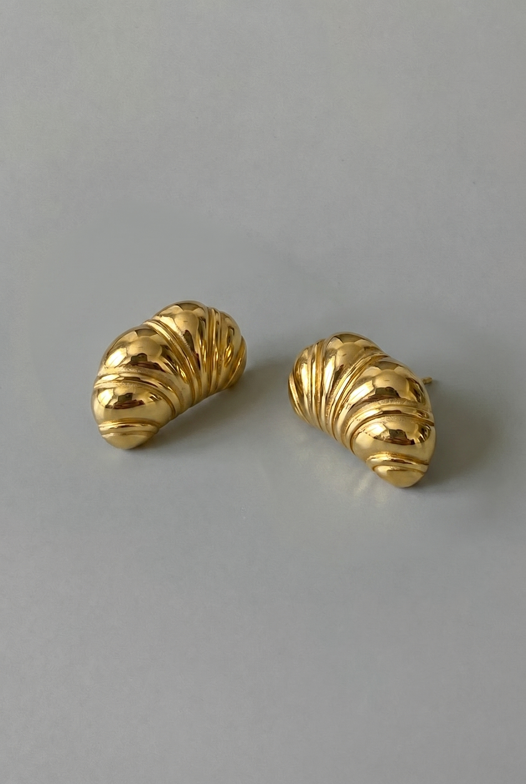 Pair of gold earrings on a gray background