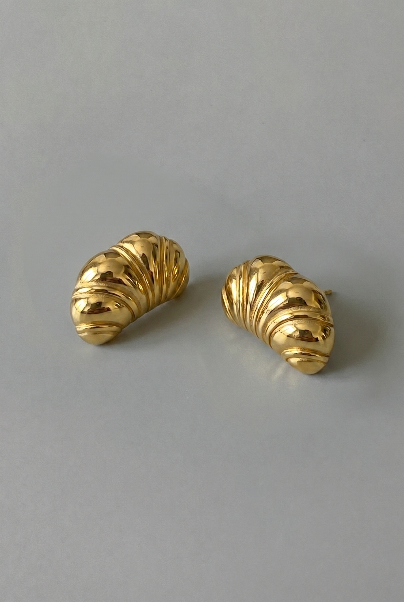 Pair of gold earrings on a gray background