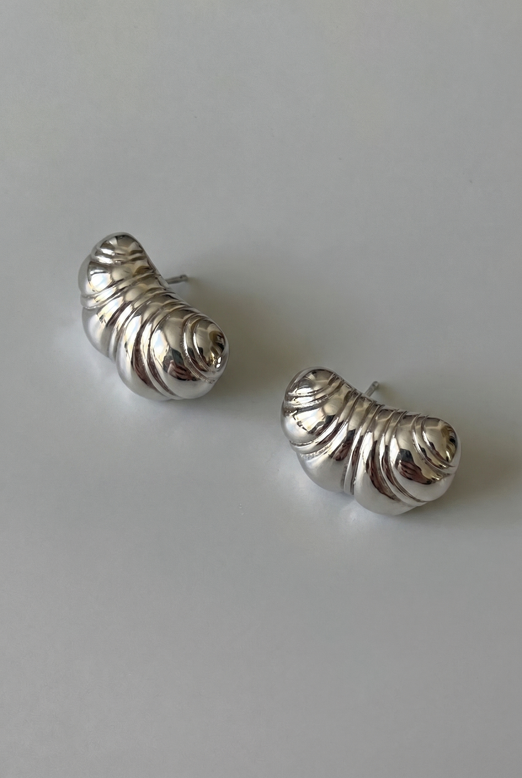 Pair of silver spiral earrings on a light gray background