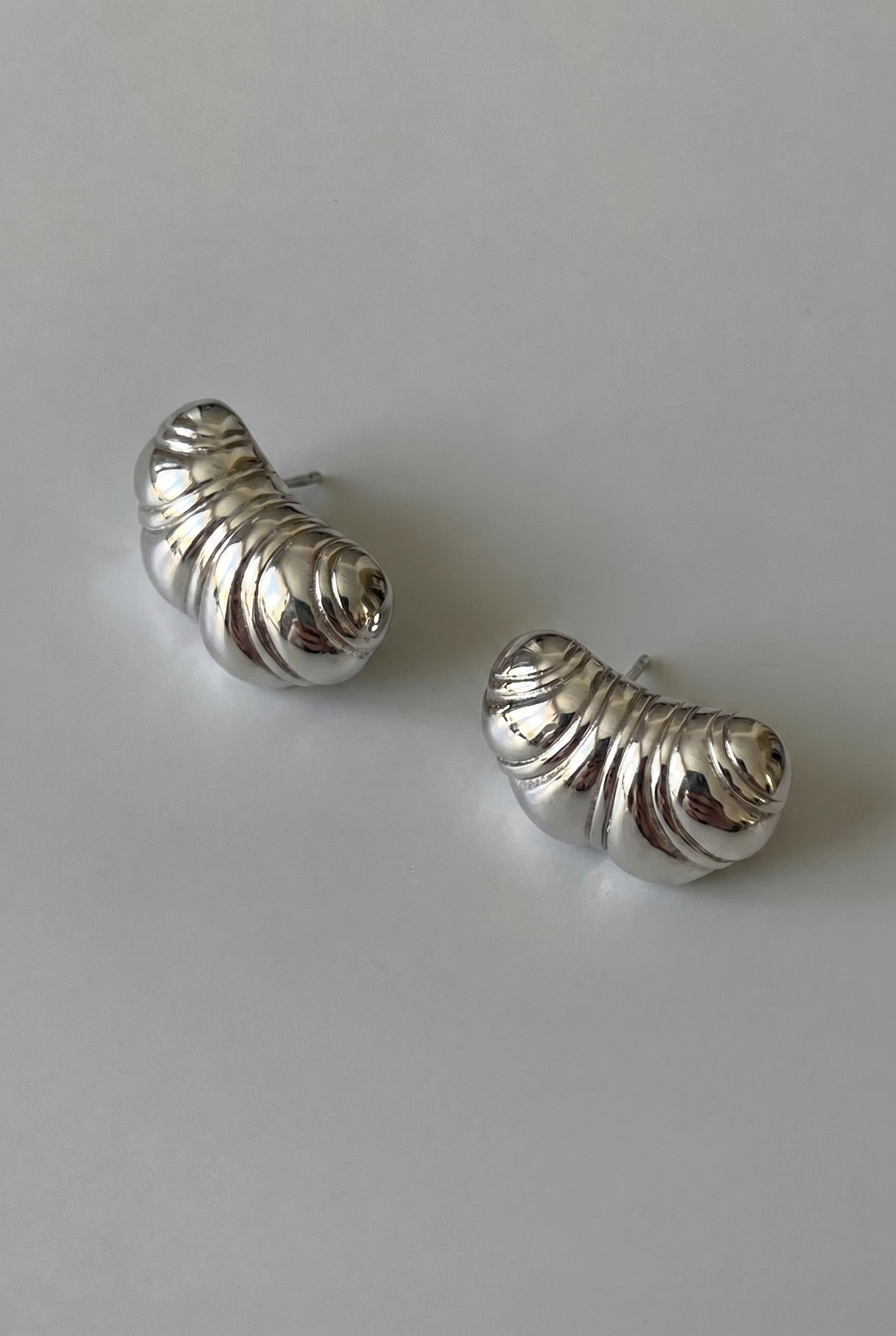 Pair of silver spiral earrings on a light gray background