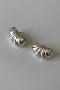 Pair of silver spiral earrings on a light gray background