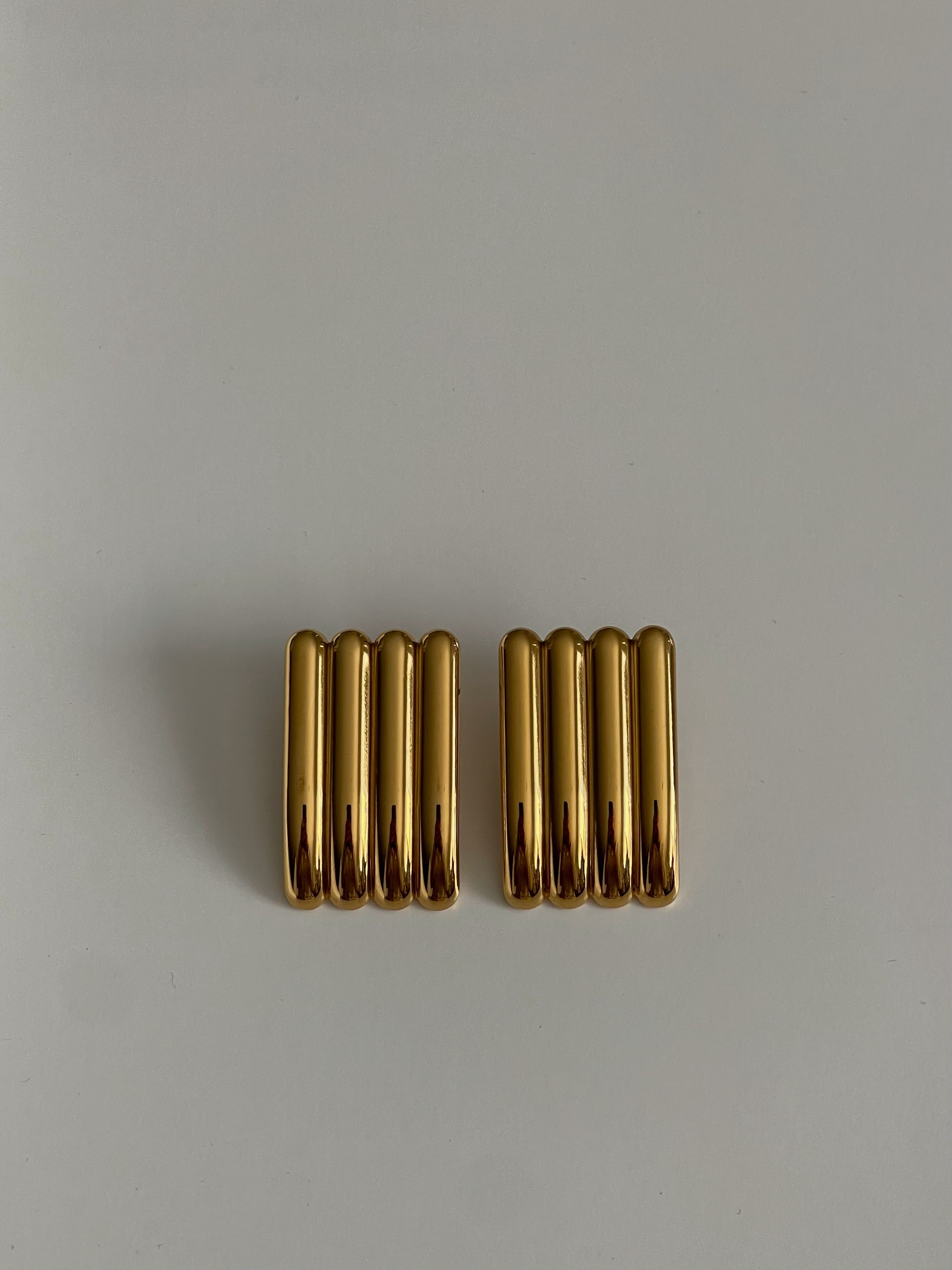Pair of gold earrings on a light gray background