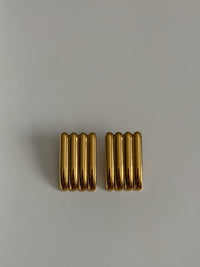 Pair of gold earrings on a light gray background