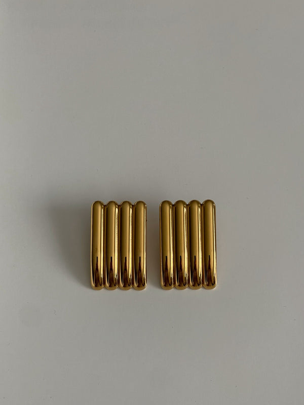 Pair of gold earrings on a light gray background