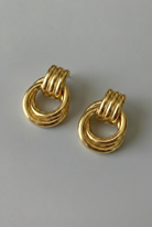 Pair of gold hoop earrings on a gray background