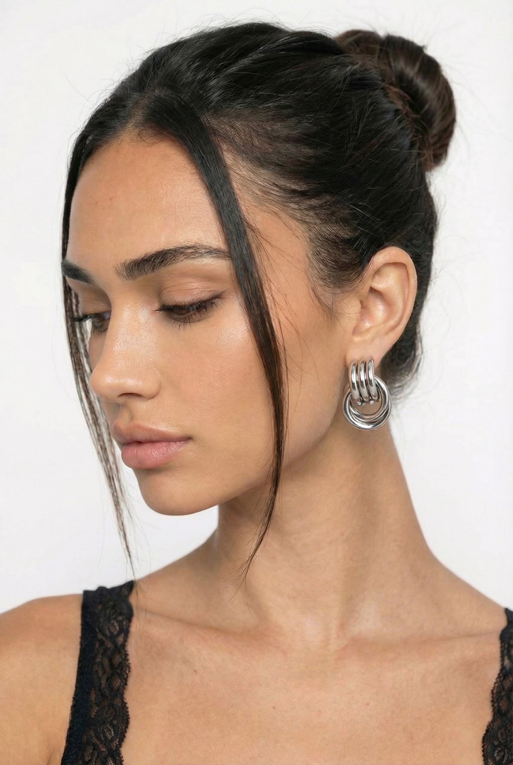 Woman wearing a black lace top with a plain background