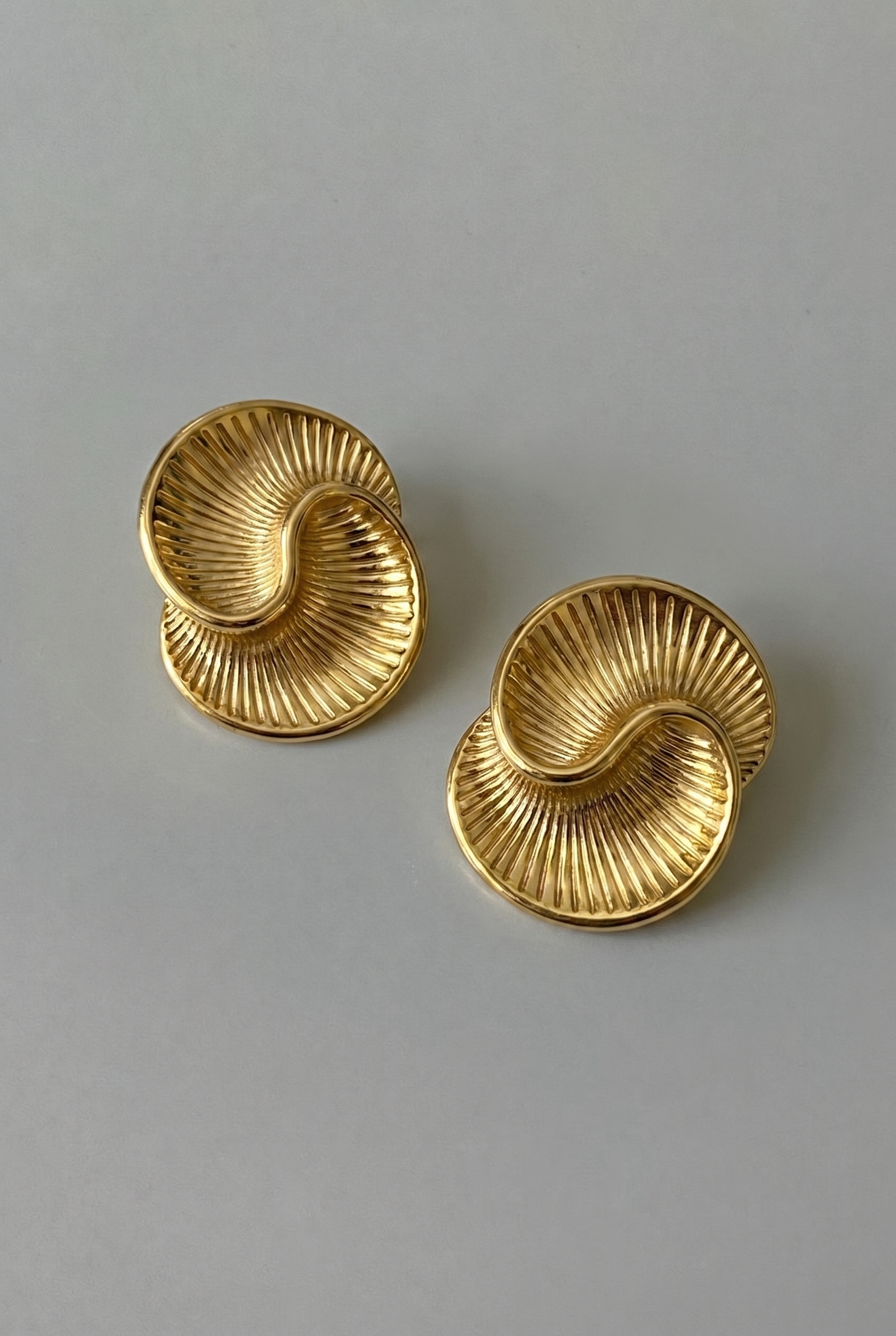 Pair of gold earrings on a gray background