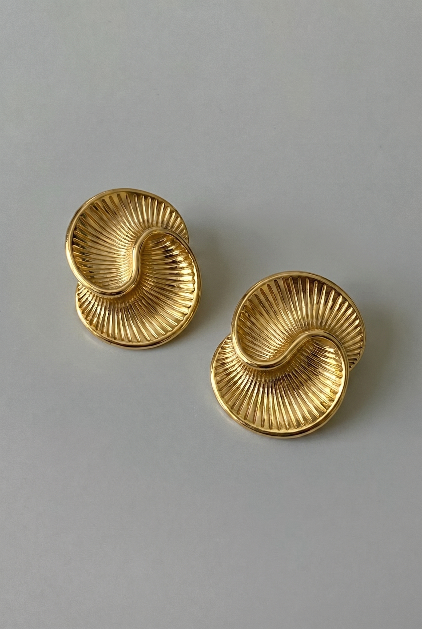 Pair of gold earrings on a gray background